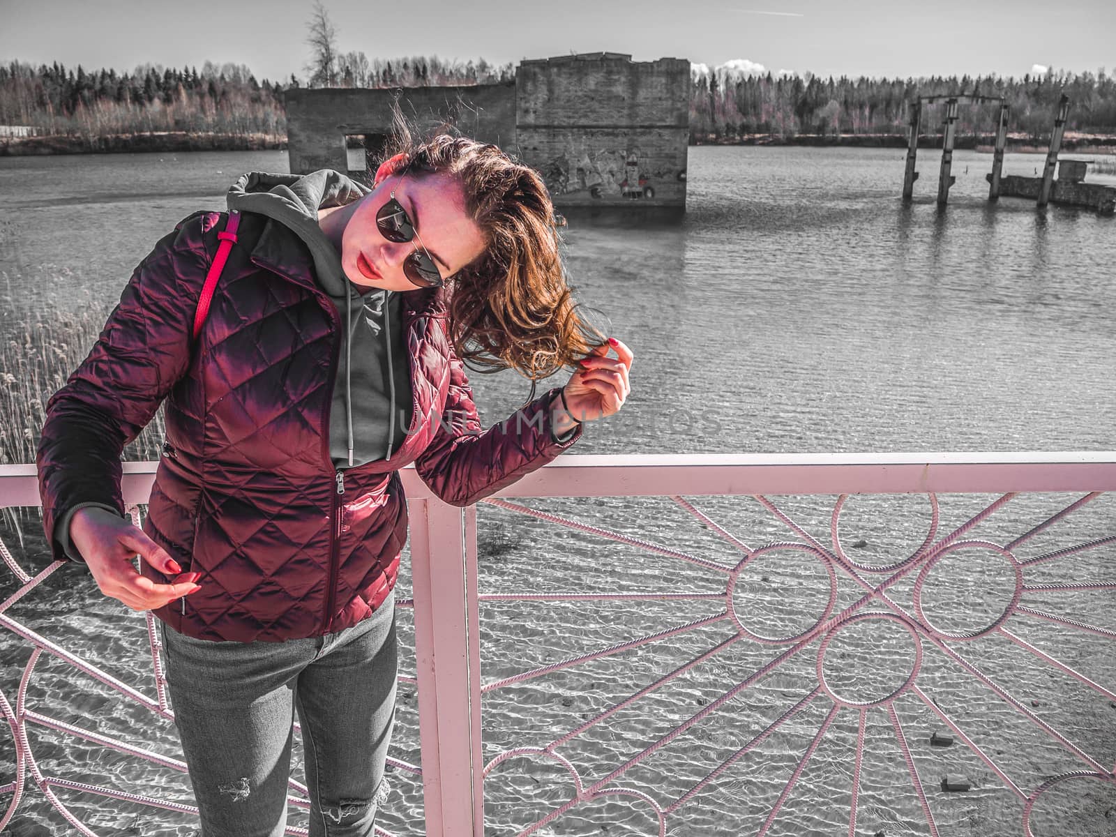 young woman with red jacket and abndoned Quarry Of Rummu, Estonia on the background. Scenic View Of Land Against Clear Blue Sky. Panoramic View.