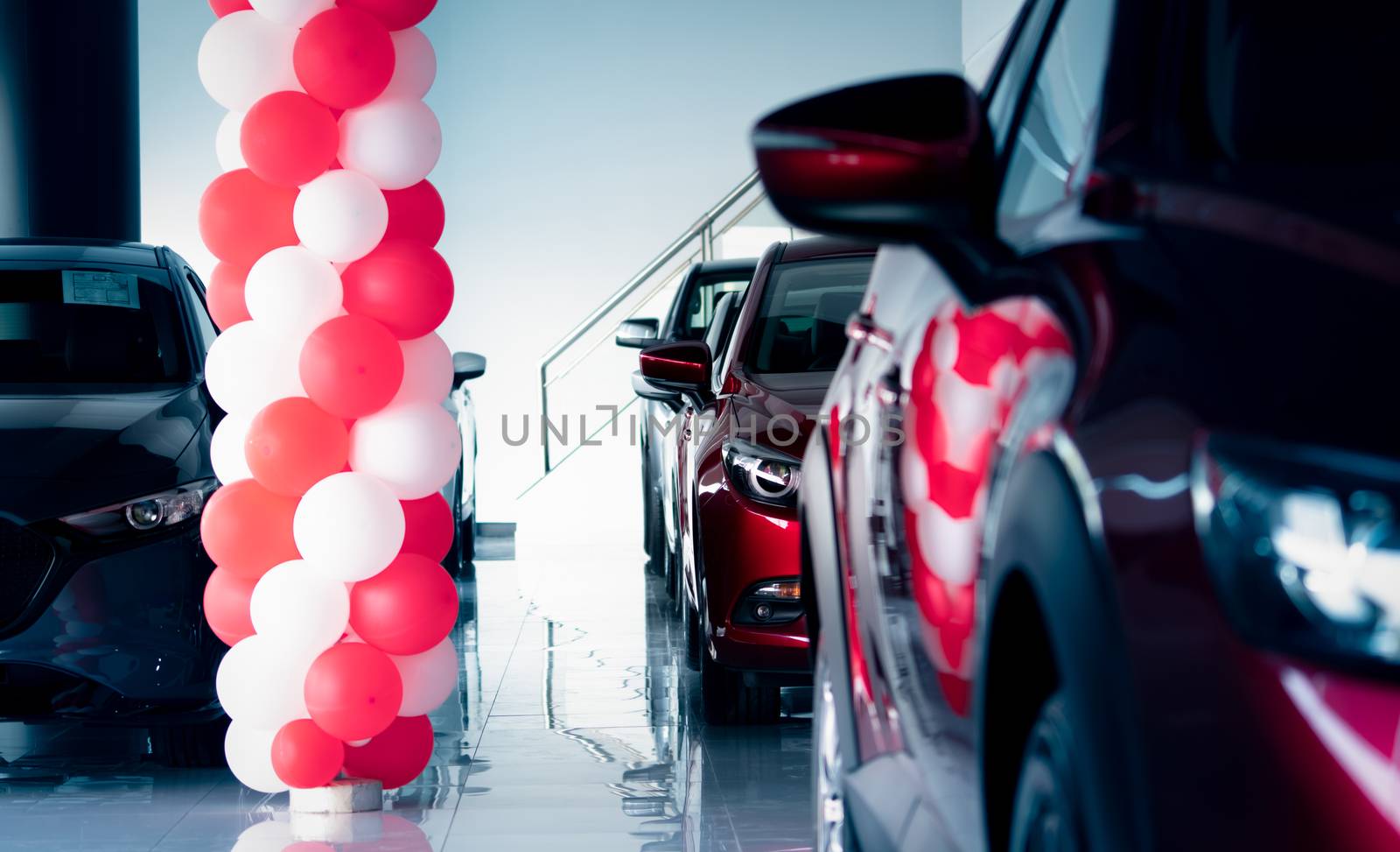 New and shiny luxury SUV car parked in modern showroom with sale promotion events. Car dealership office. Electric car business. Automobile leasing. Automotive industry. Showroom decor with balloons.