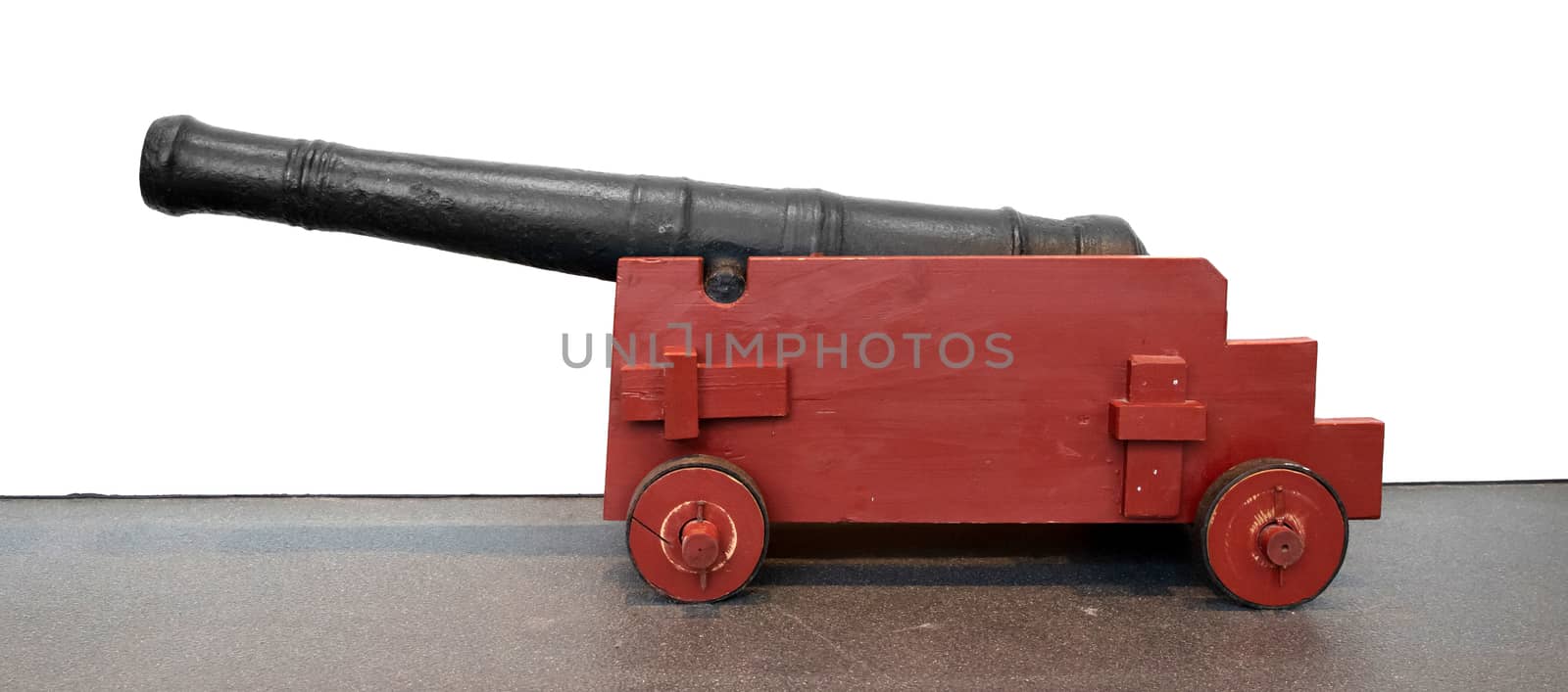 Old medieval canon isolated against a white wall