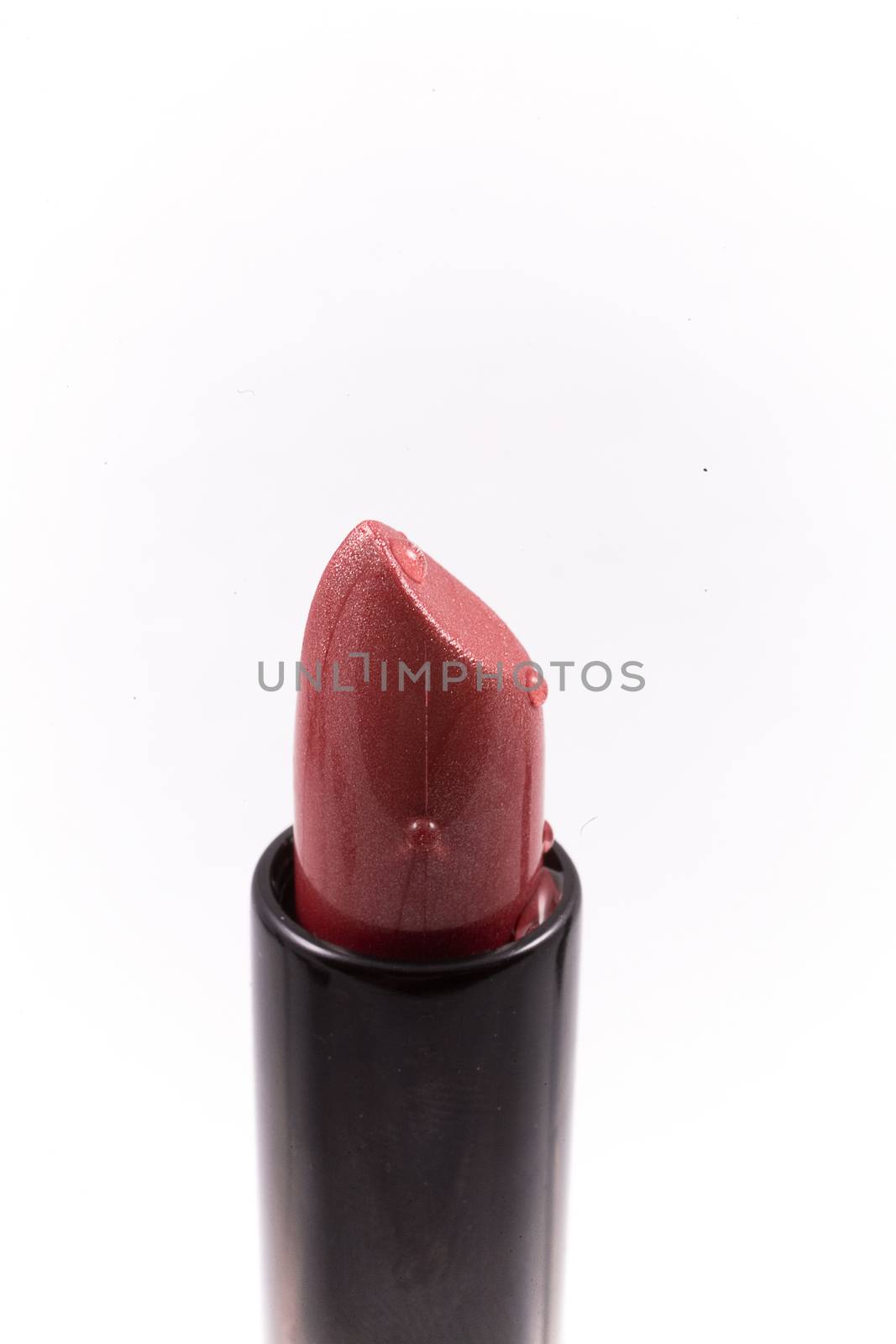 red lipstick in a black body on a white isolated background by Lukrecja