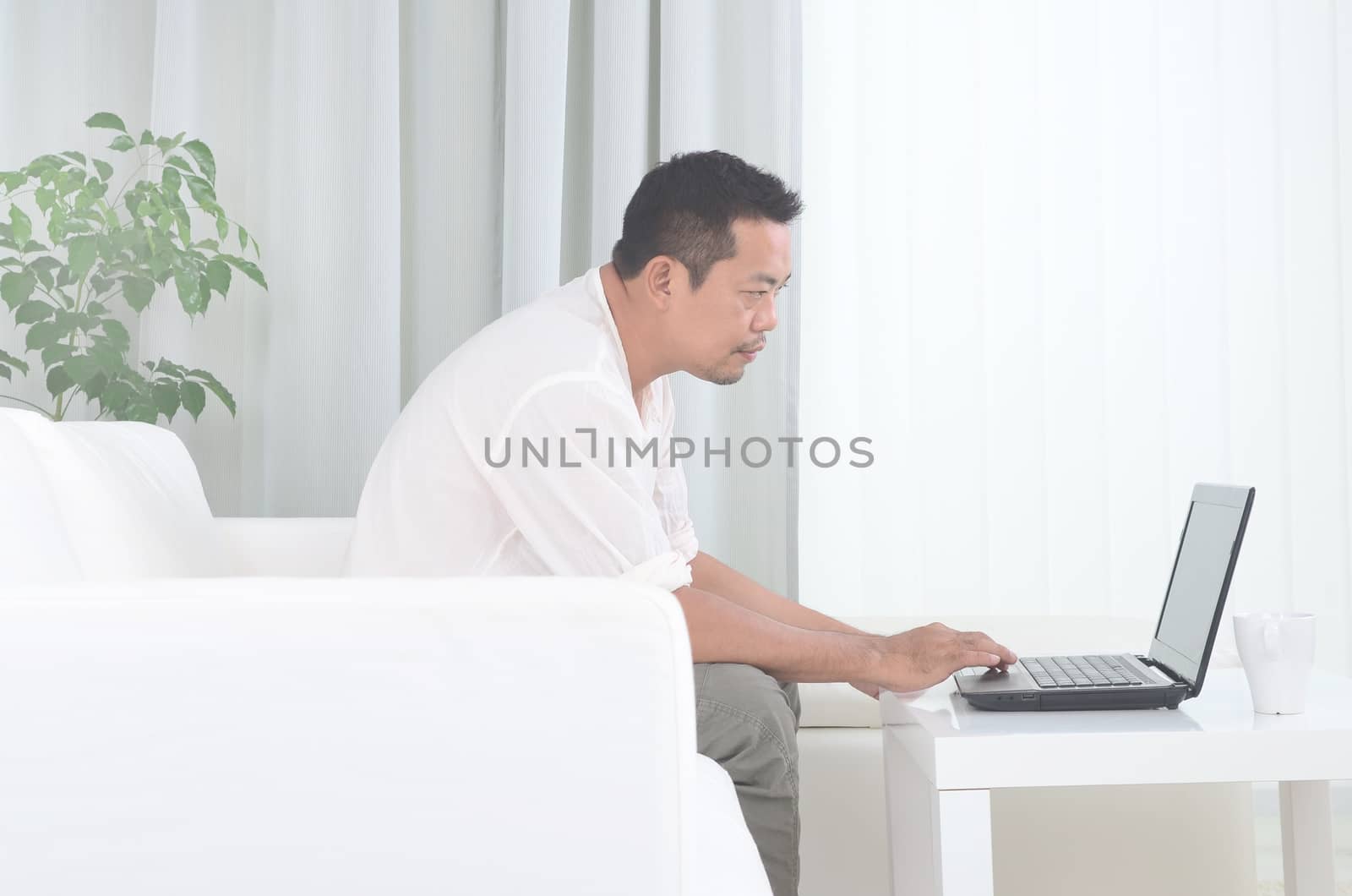 Modern asian man working remotely from home during Coronavirus pandemic in the world.