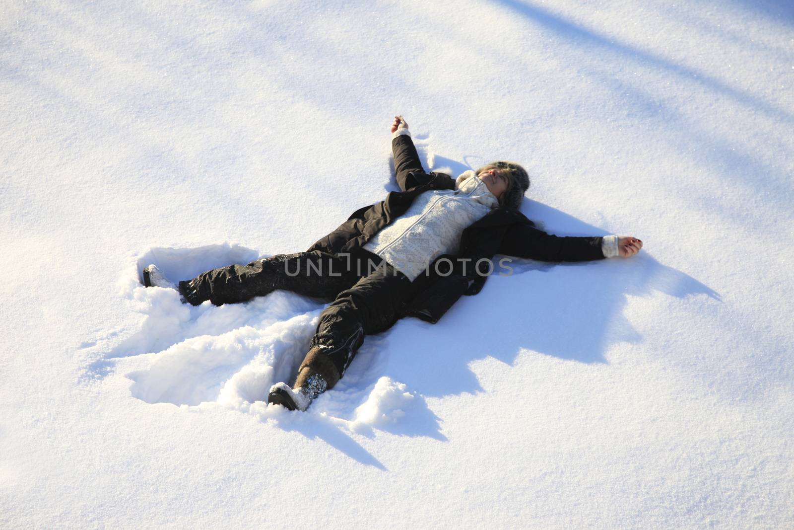 Adult woman lying on clear snow