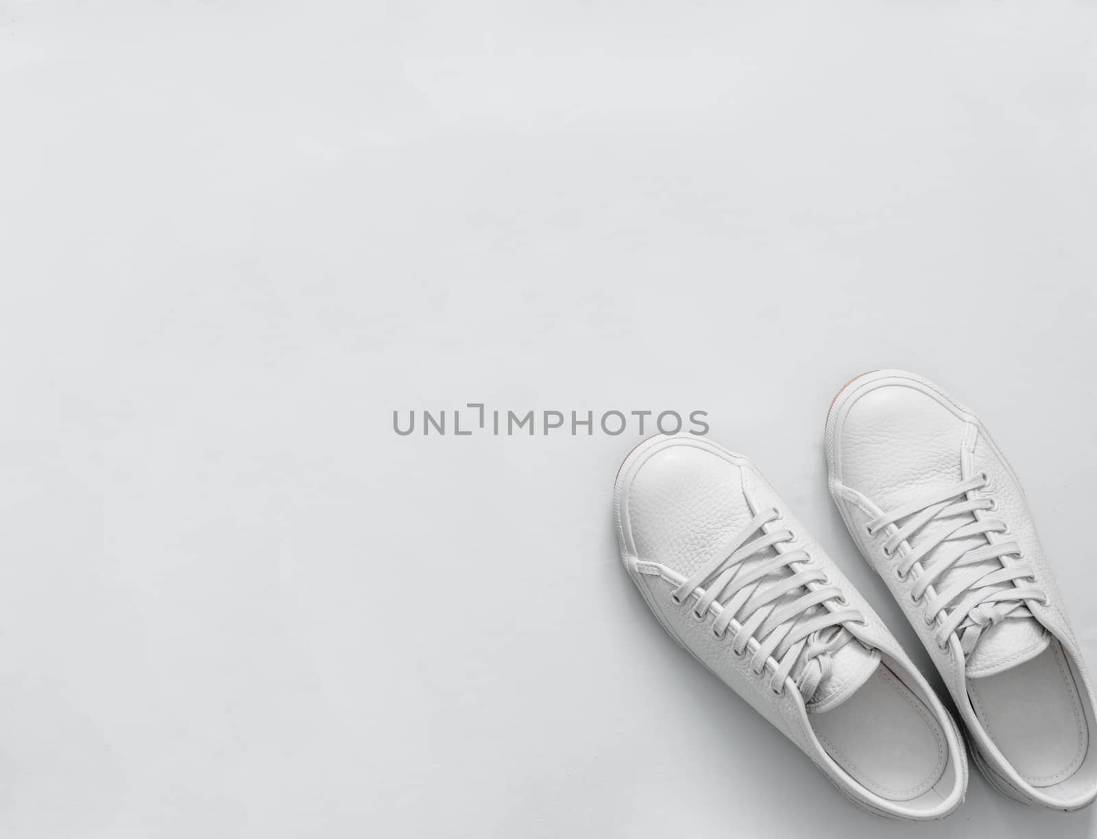 White sneakers on light background, copy space by fascinadora