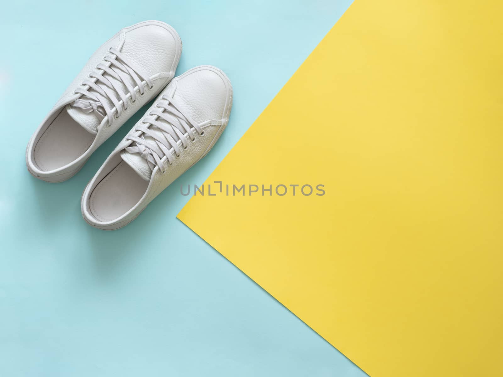 White sneakers on blue and yellow, copy space, top view by fascinadora