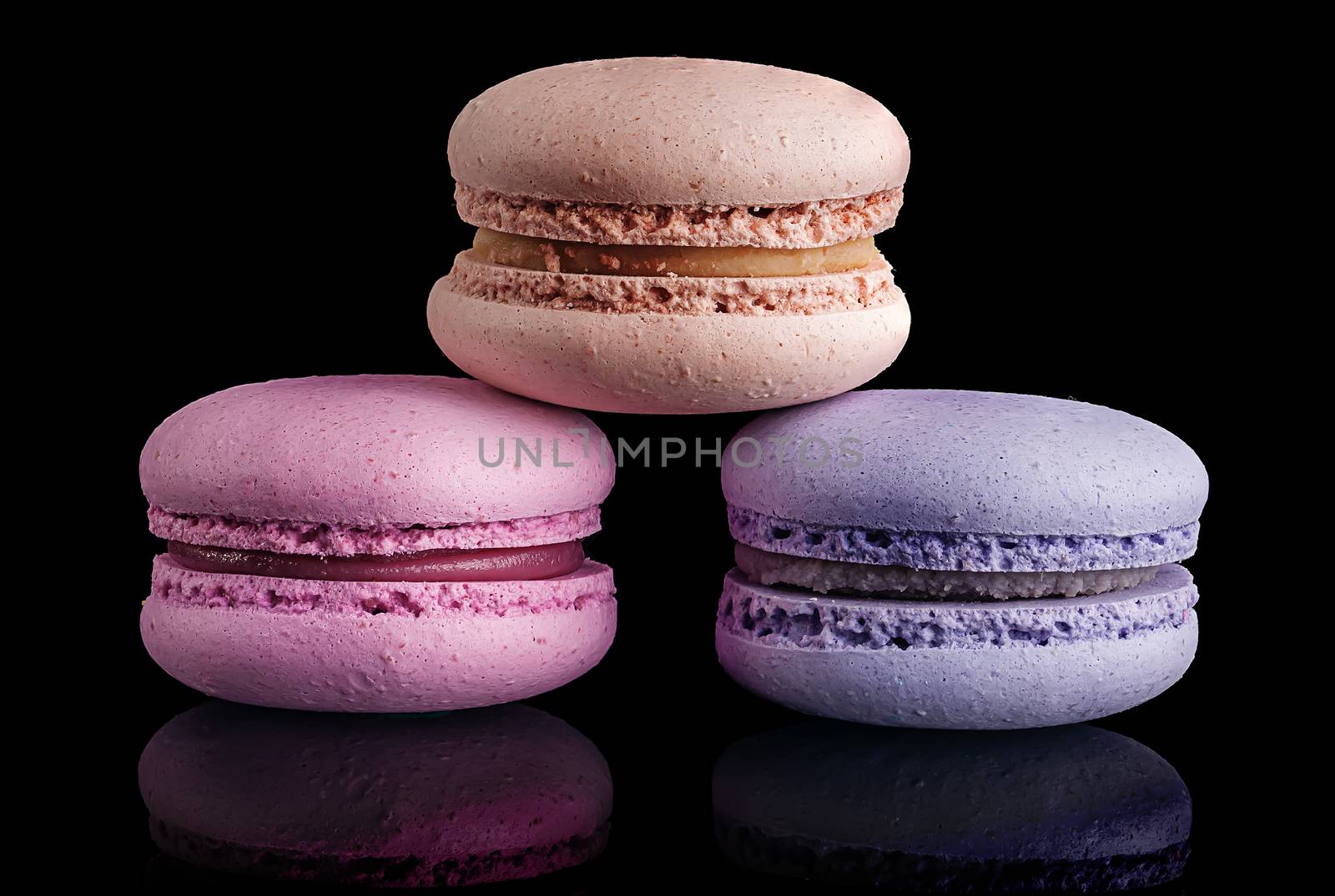 Three macaroon pyramid on black background with reflaction