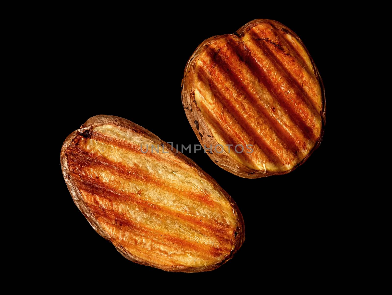 Two slices of grilled potatoes rotated on black background