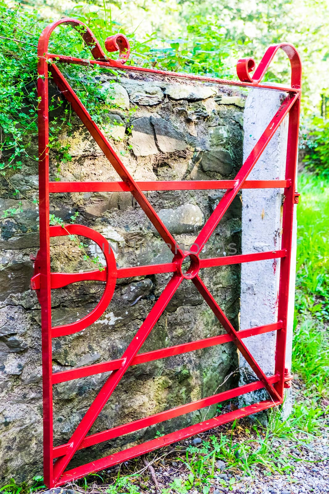 detailed vintage red painted steel gate in rural setting UK by paddythegolfer