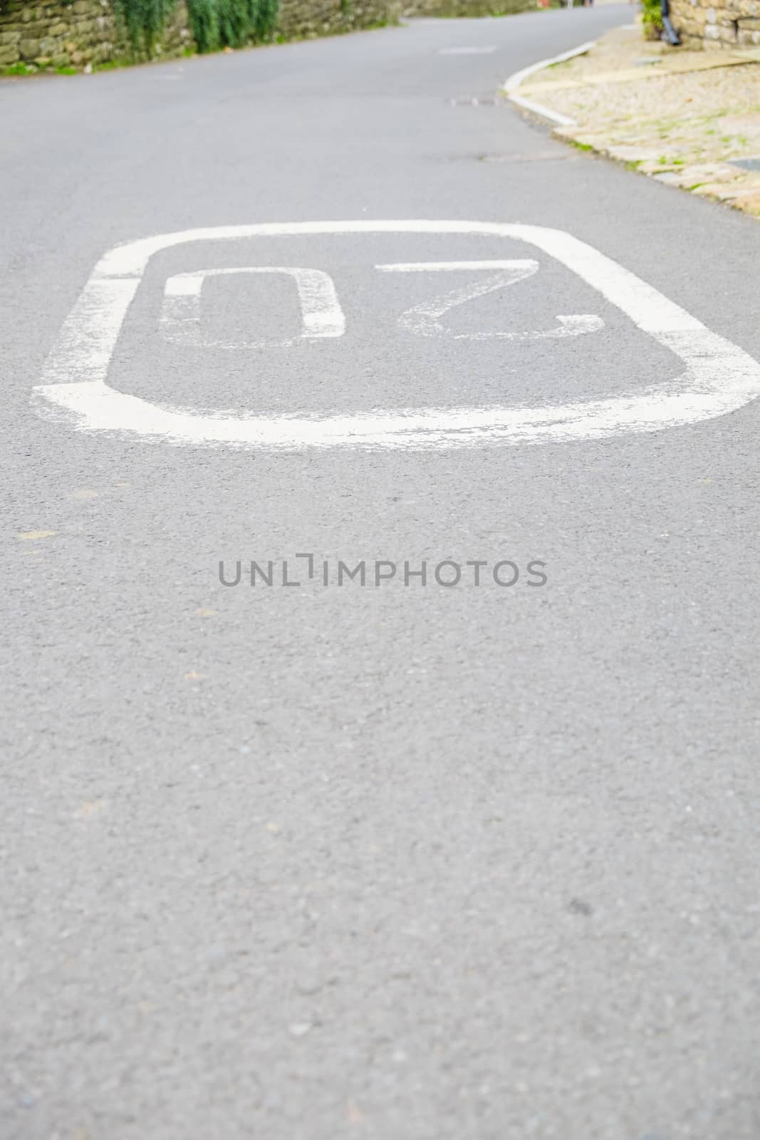 a speed limit sign painted on the road UK