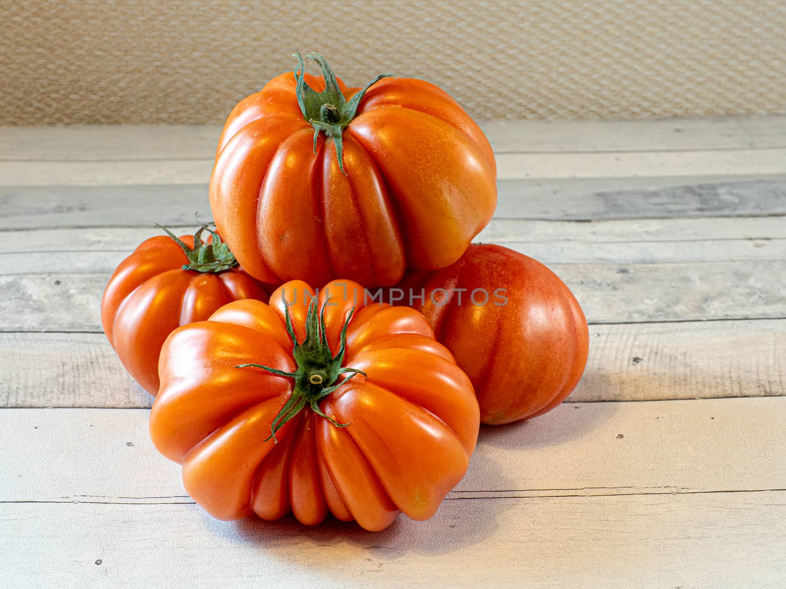 four tomatoes on a light table by jmagfoto