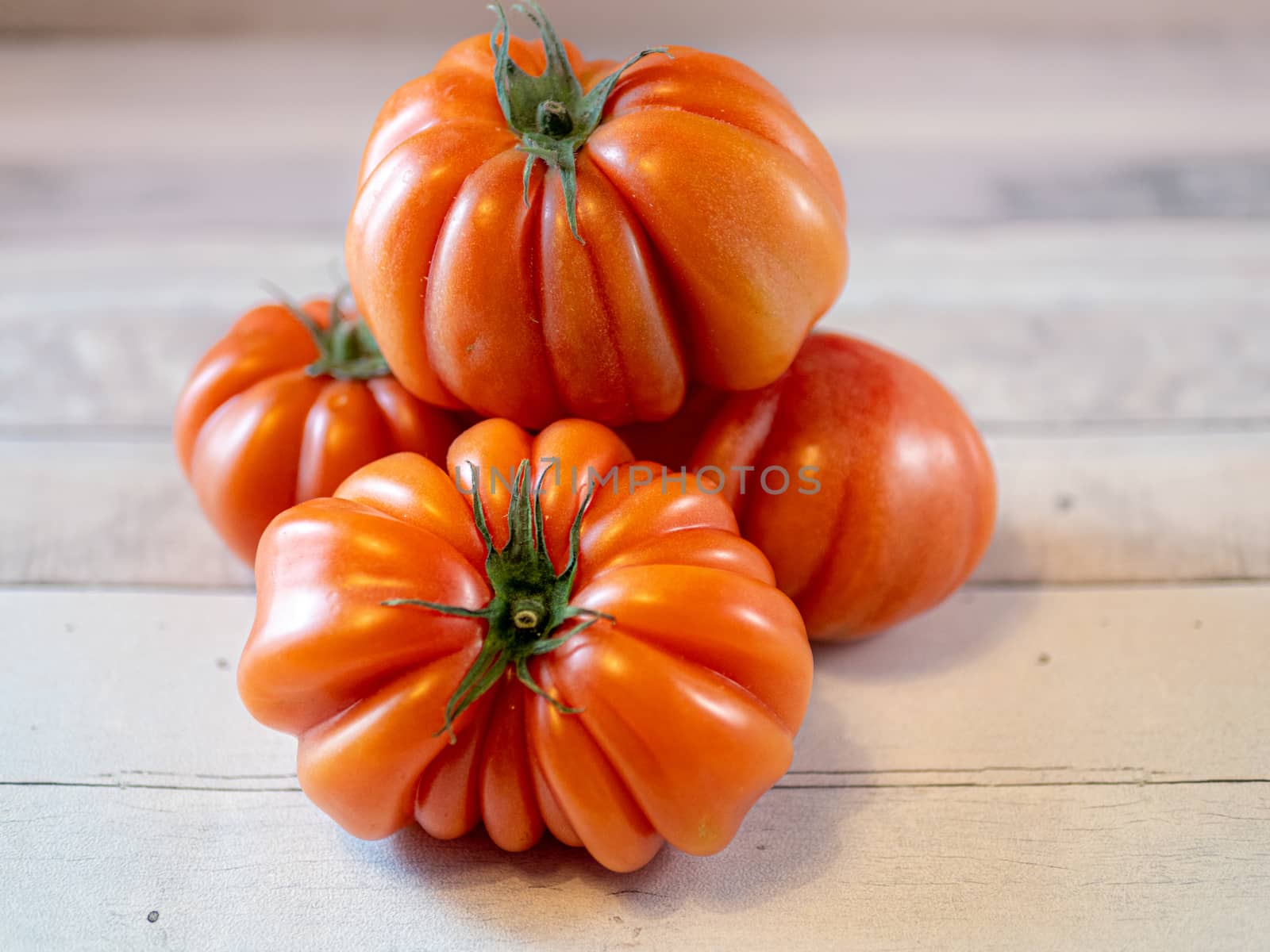 four tomatoes on a light table