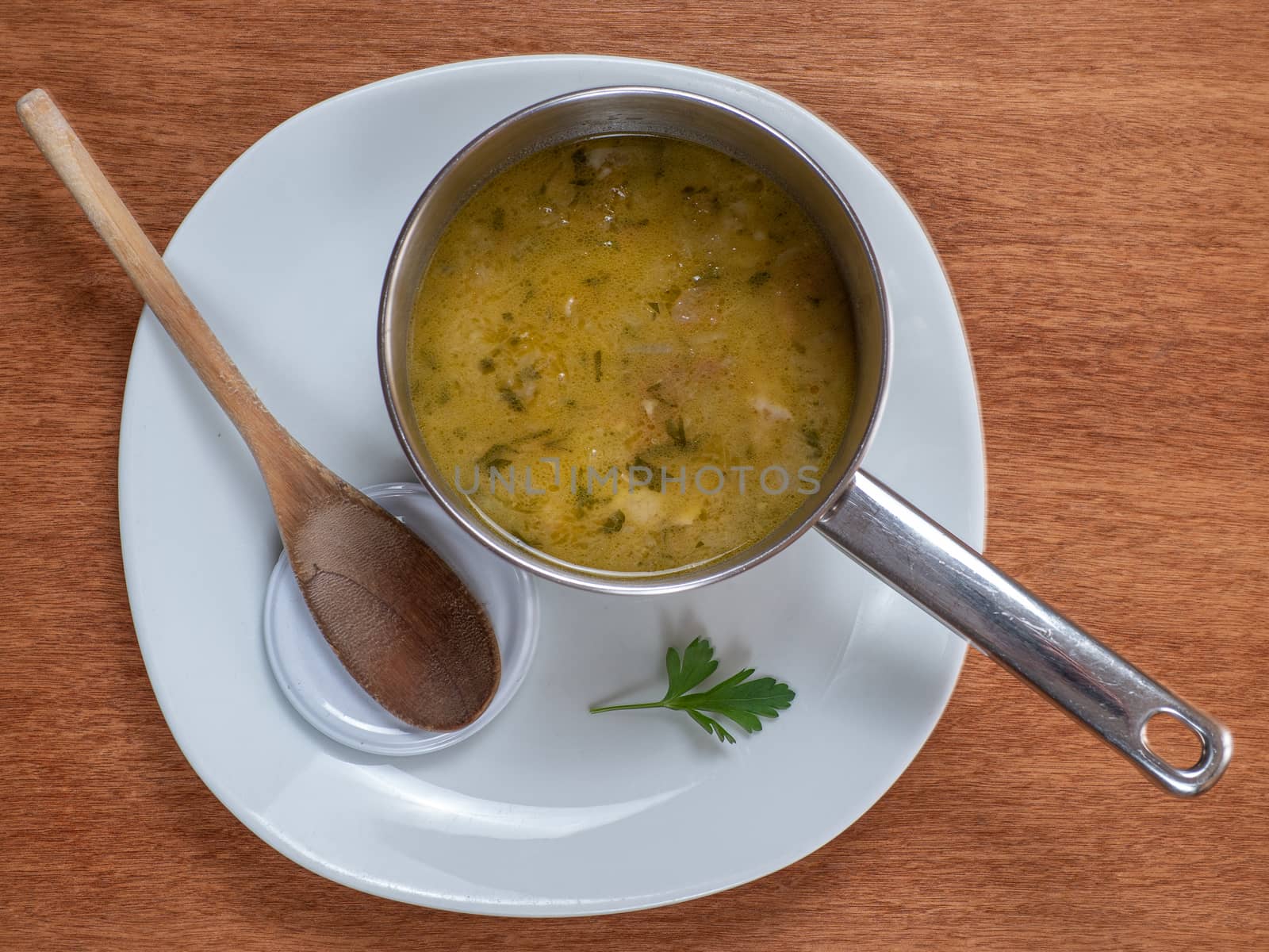 soup in a bowl on a white plate by jmagfoto