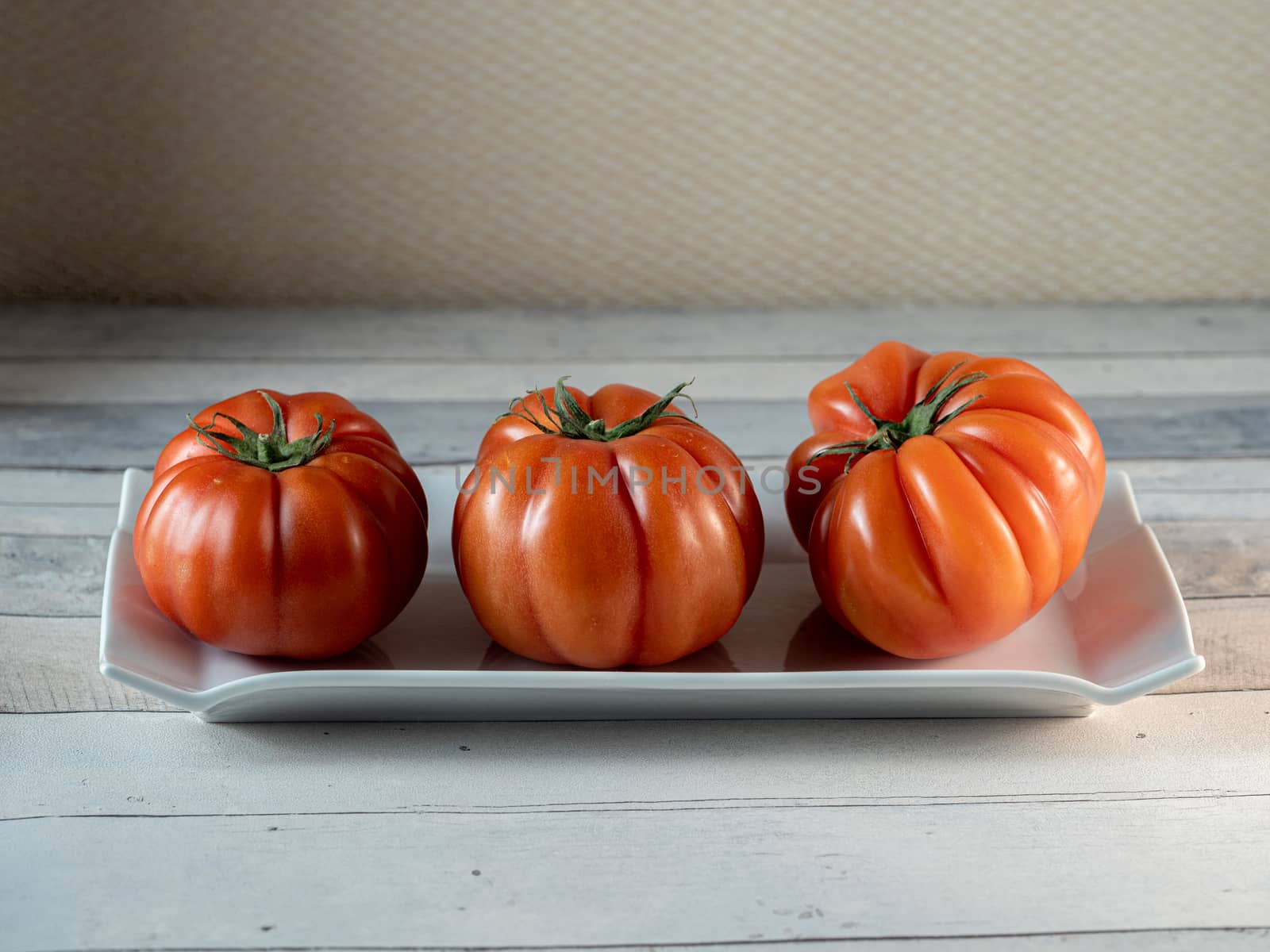 tomatoes in white plate on light table