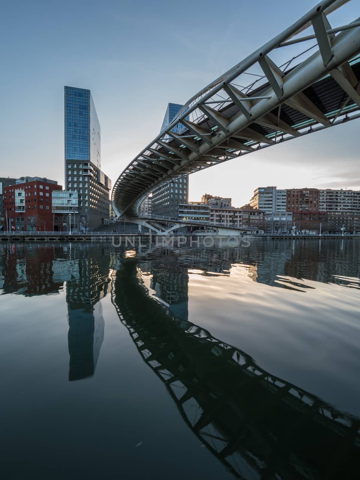 twin skyscrapers with white bridge spanning a river