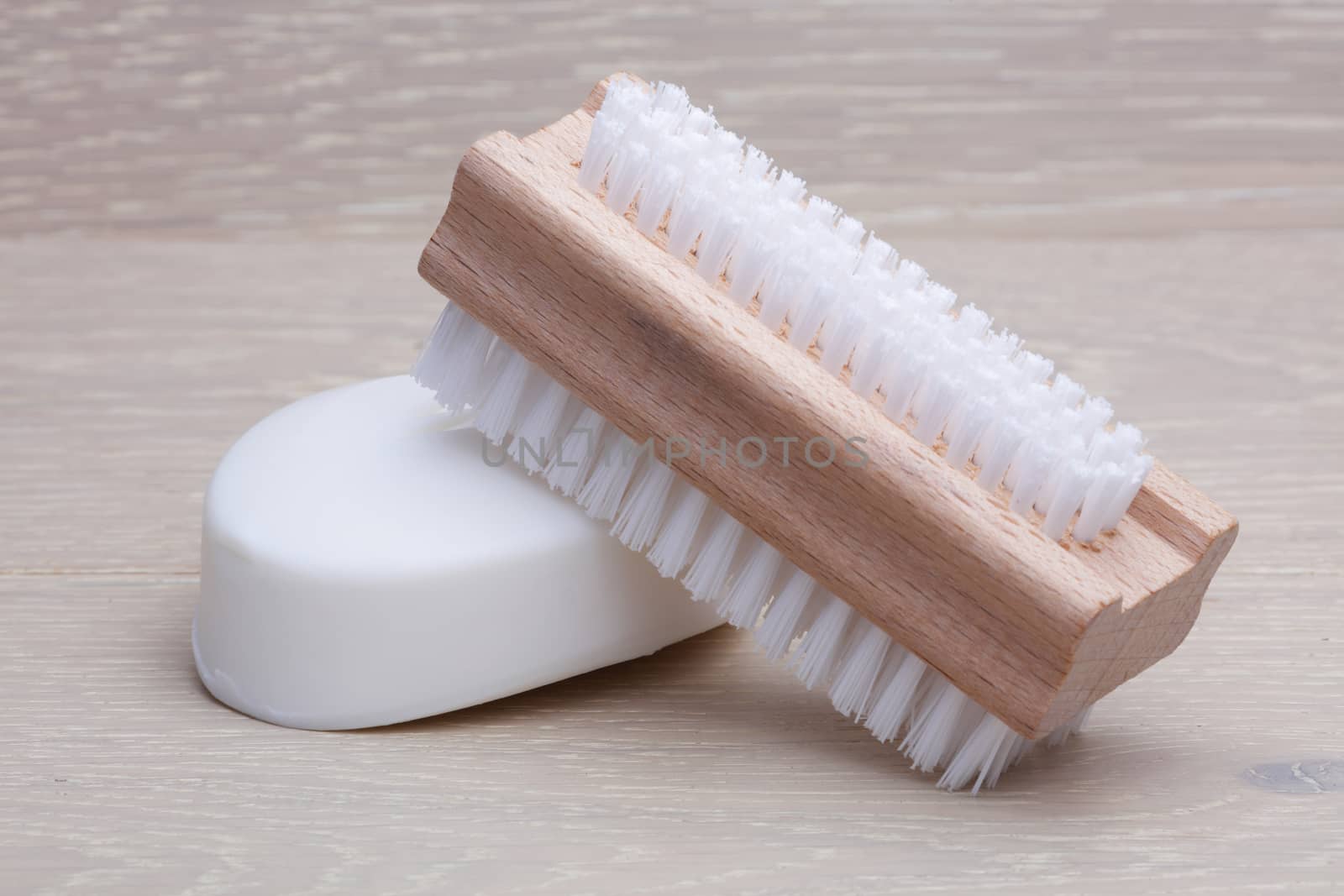 A classic wooden nail brush and soap on wood background