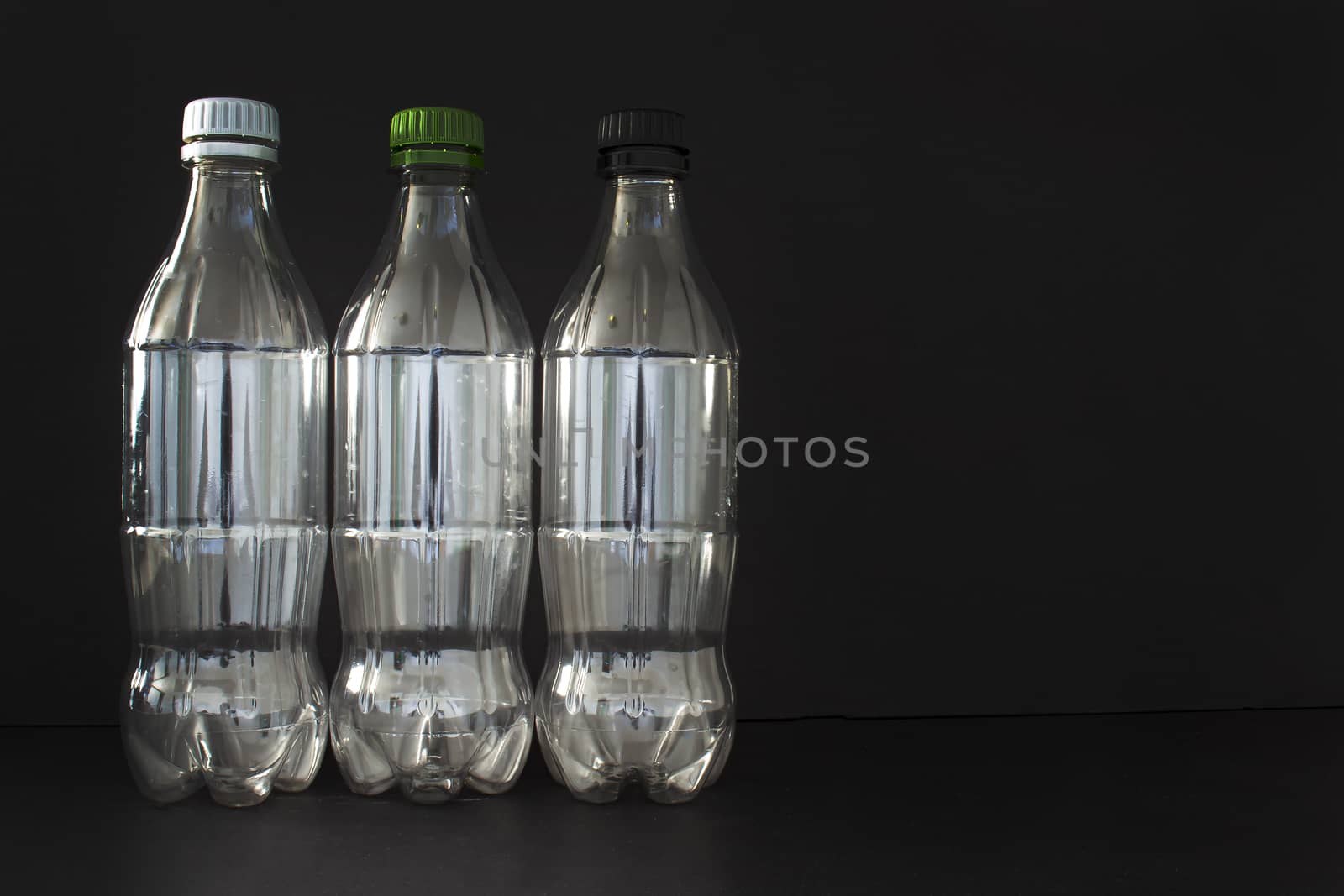 Empty plastic soft drink bottles on a black background