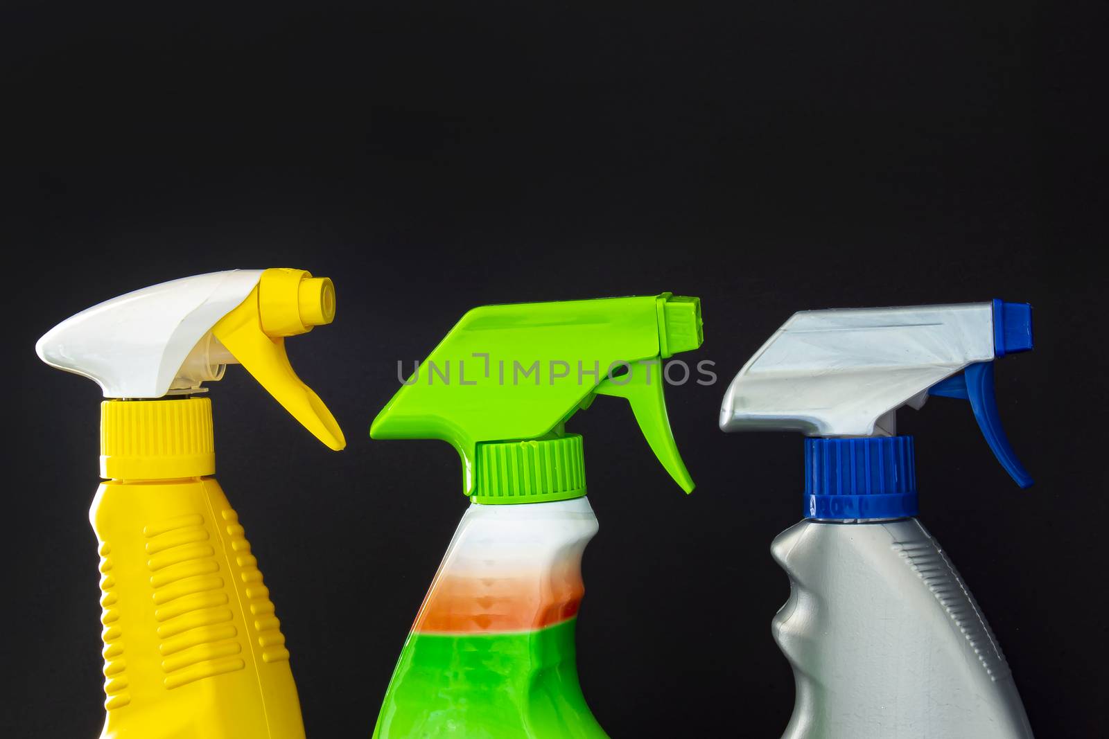 Close up of spray cleaners bottles on a black background by oasisamuel
