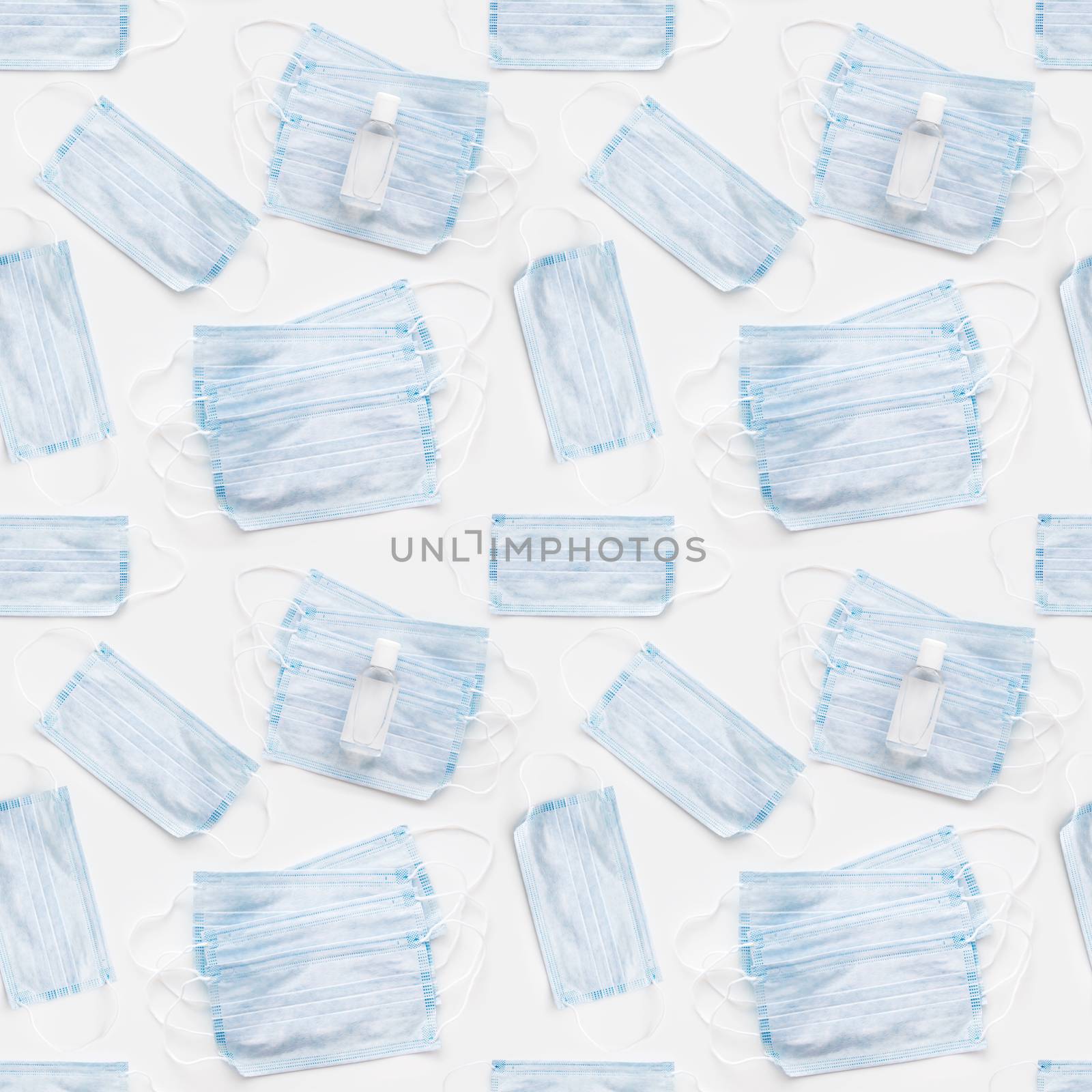 Top view on scattering blue protective medical masks and sanitizer gel. Photo seamless pattern of medical masks. Coronavirus COVID-19 concept on white background.