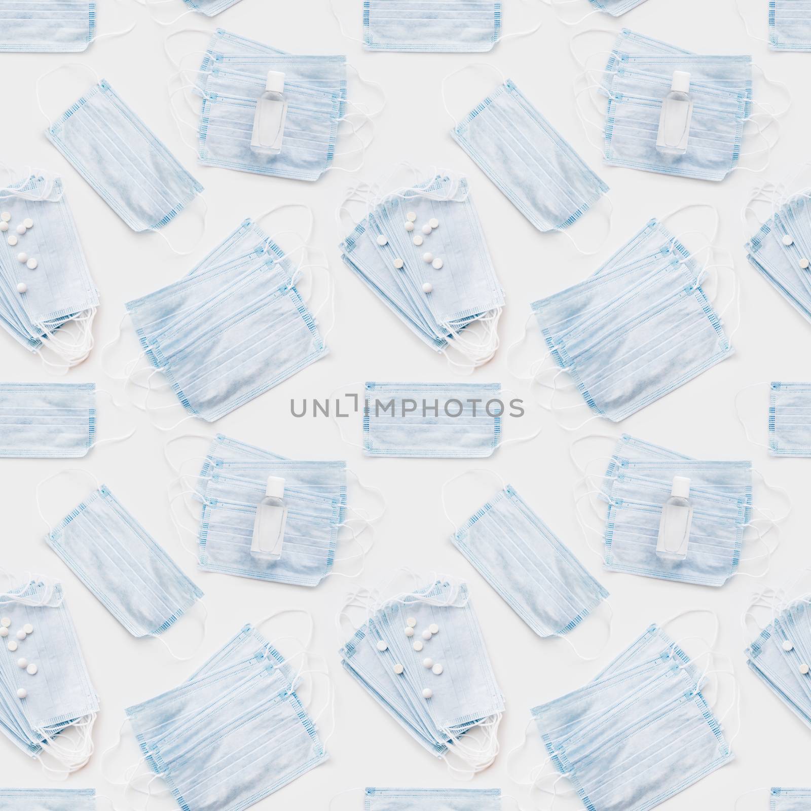 Top view on scattering blue protective medical masks, sanitizer gel and scattering pills. Photo seamless pattern of medical masks. Coronavirus COVID-19 concept on white background.