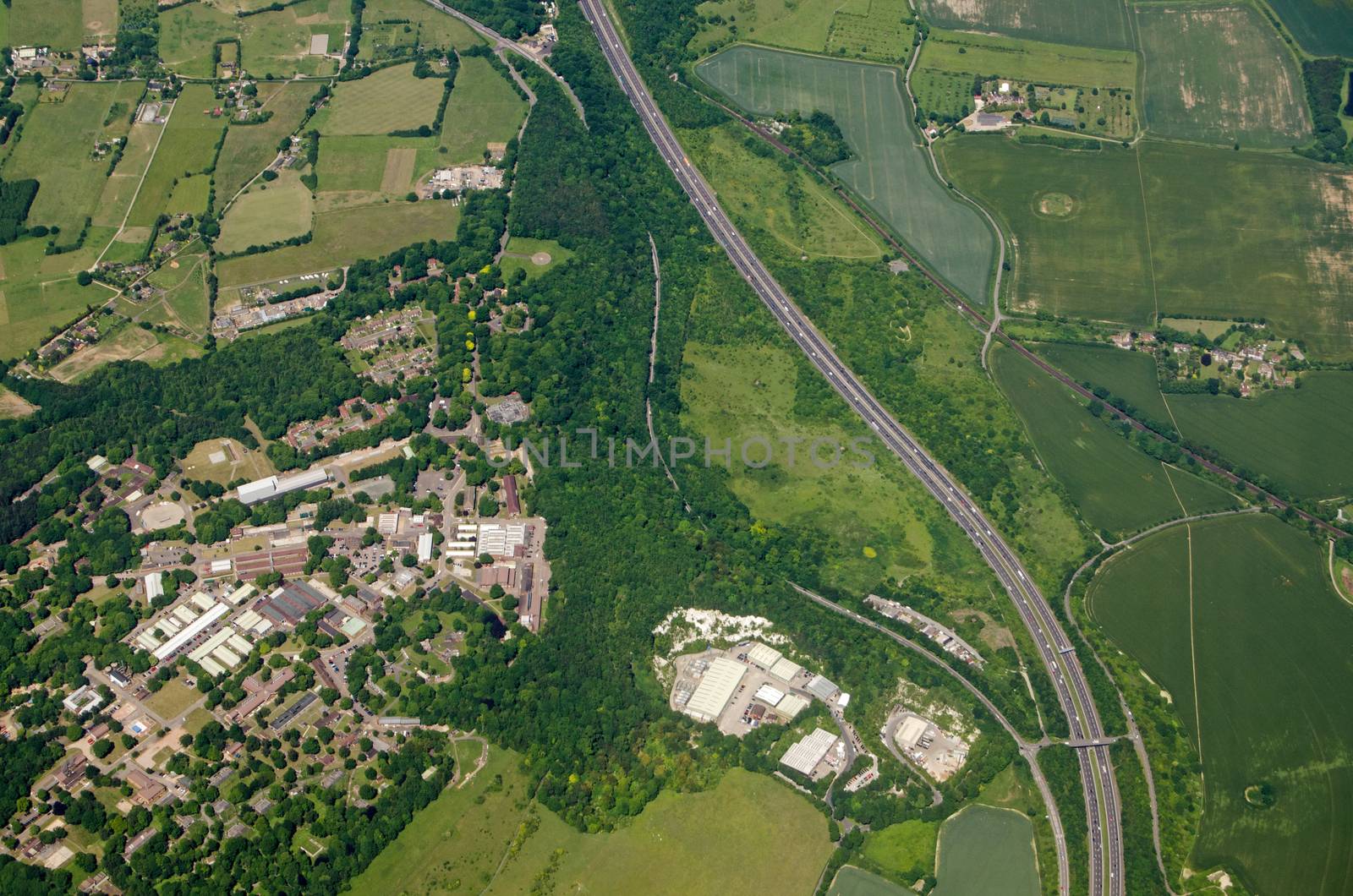 Aerial view of Fort Halstead, home to the Defence Science and Technology Laboroatory run by Qinetiq for the Ministry of Defence.  Sunny summer day near Sevenoaks, Kent with the M25 motorway, railway line and some ancient tumulii visible in the fields.