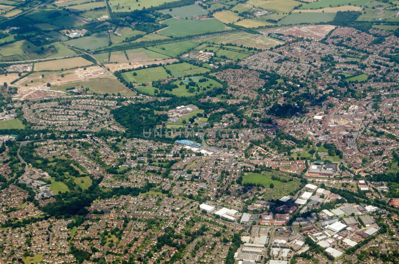 Aerial view of the Berkshire town of Wokingham, seen on a sunny summer day.  The blue structure of the railway station's multi-story car park is at the centre of the image with the A329(M) road cutting across the top. 