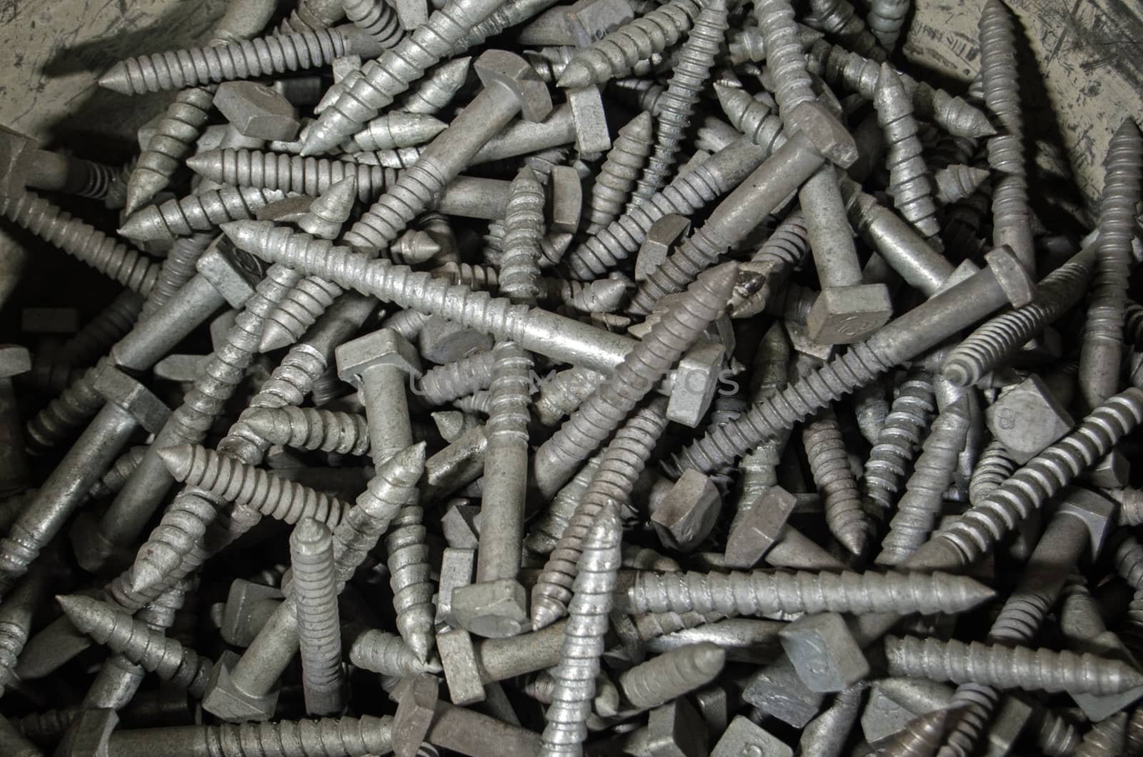 View of a bucket of large metal screws used in civil engineering projects.