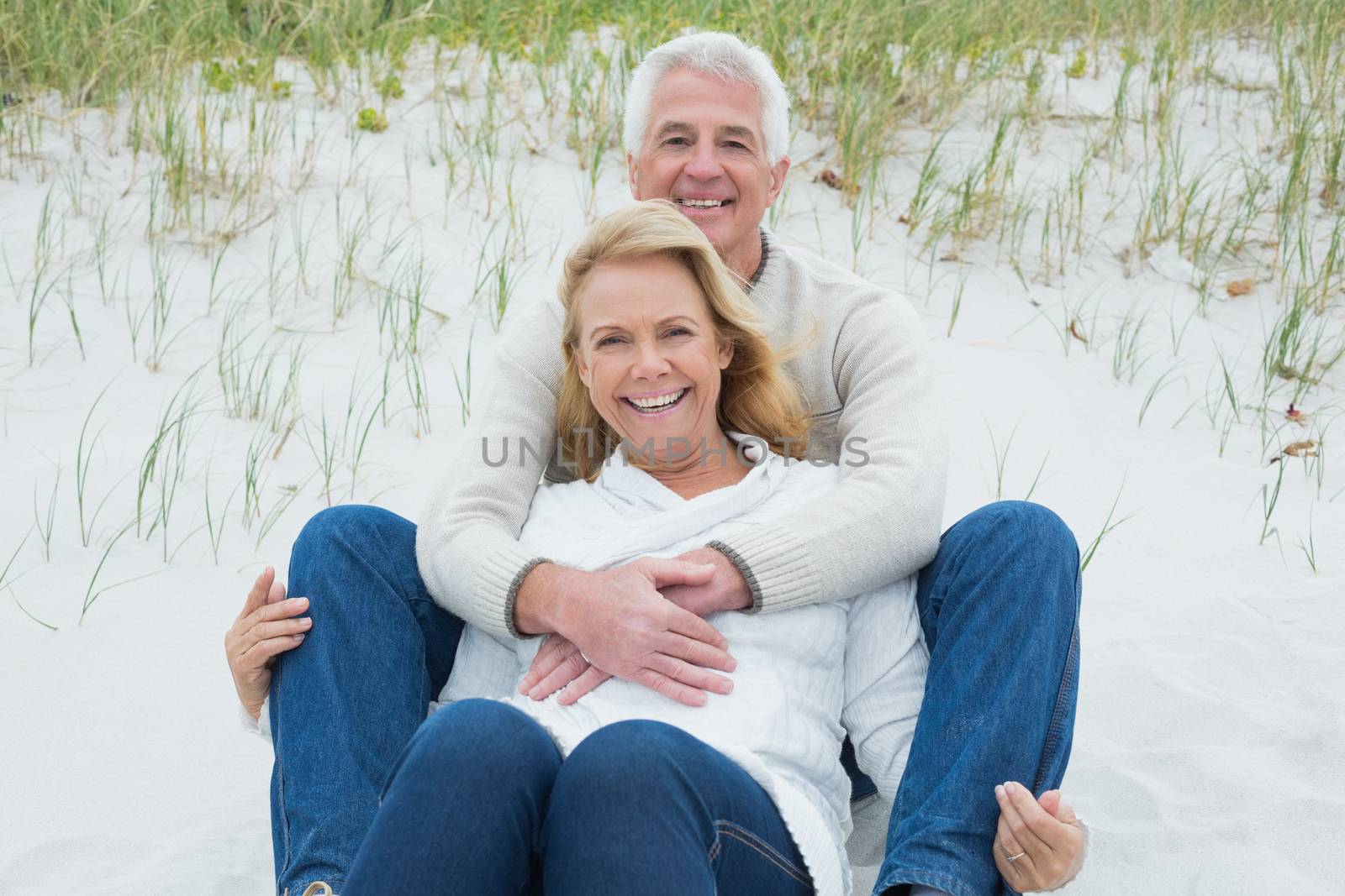 Romantic senior couple relaxing at beach by Wavebreakmedia