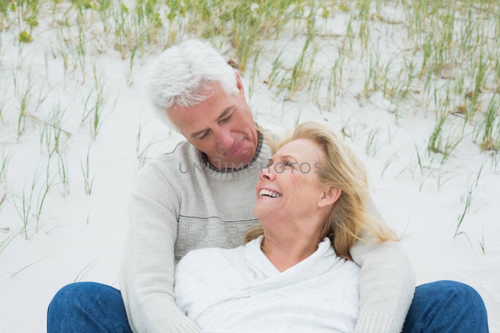 Romantic senior couple relaxing at beach by Wavebreakmedia