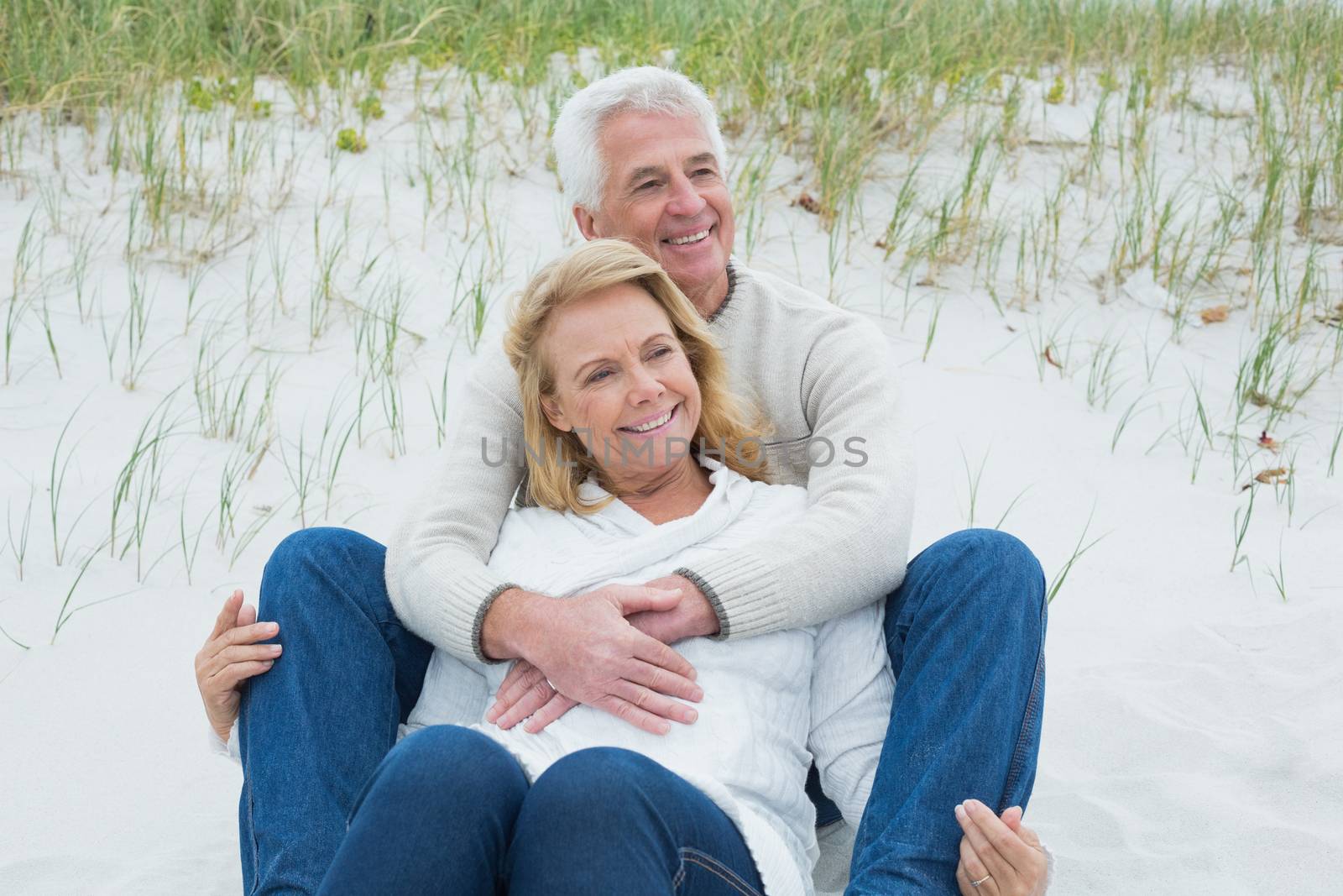 Romantic senior couple relaxing at beach by Wavebreakmedia