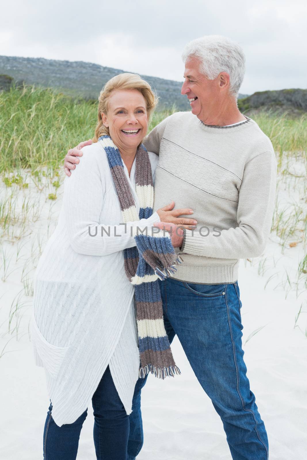 Cheerful romantic senior man and woman at the beach