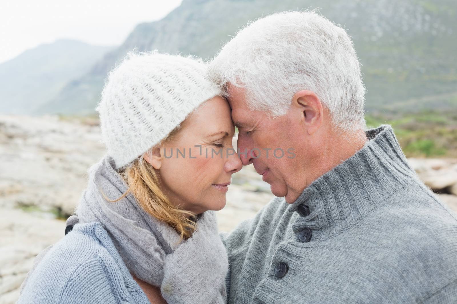 Closeup side view of a romantic senior couple together on a rocky landscape