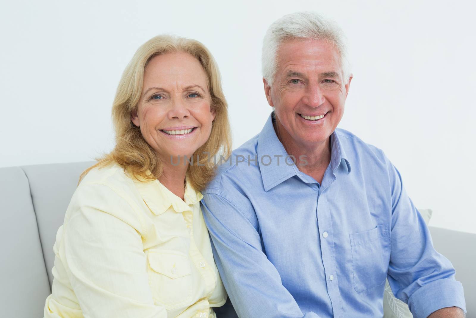 Portrait of a romantic relaxed senior couple sitting on sofa in a house