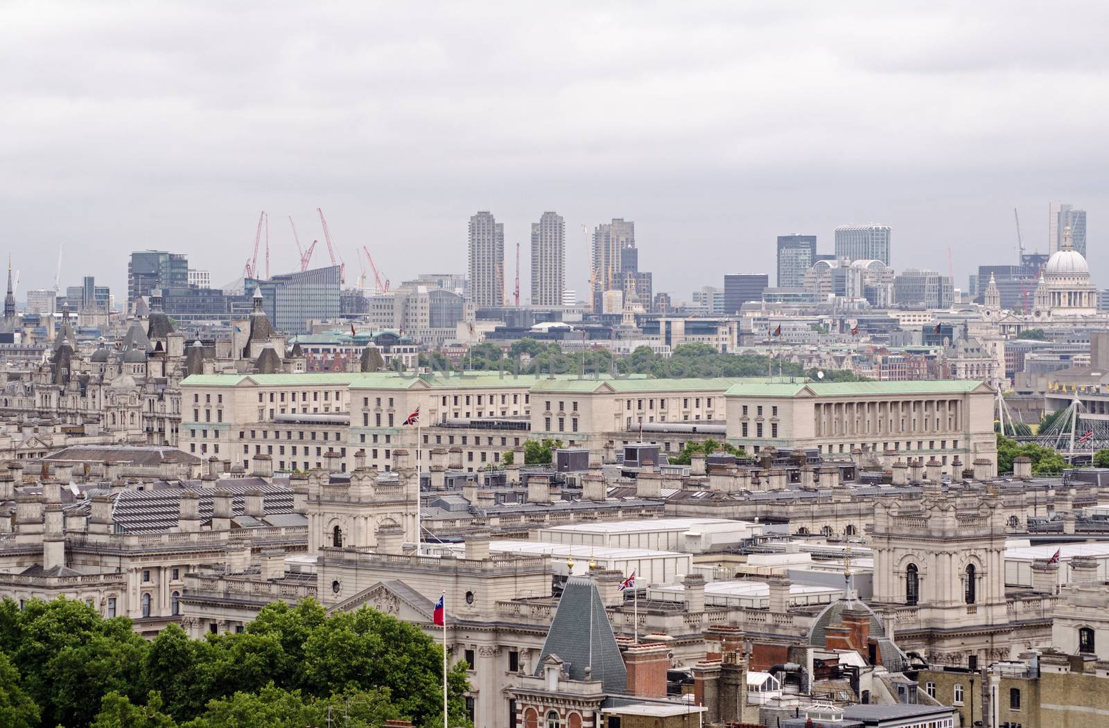 View across the rooftops of Whitehall with the green copper rooftop of the Ministry of Defence dominating the scene.  Barbican tower blocks , St Paul's Cathedral and the City of London in the distance.