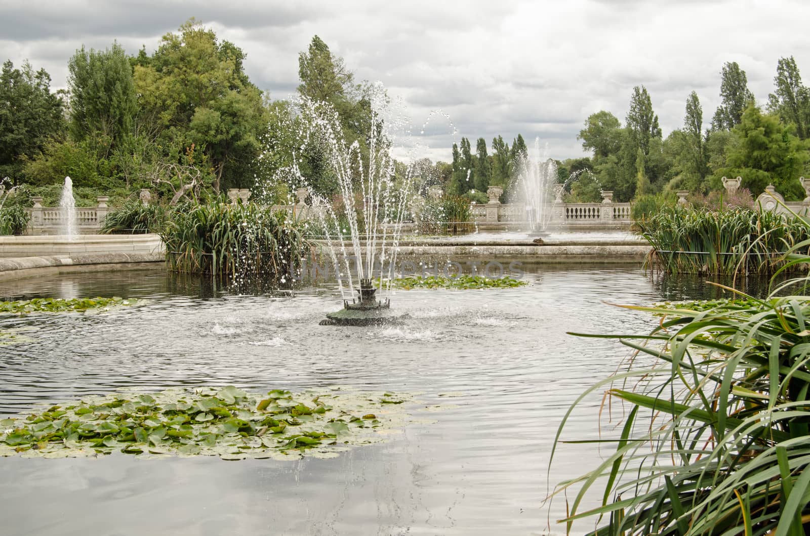 Fountains in the Italian Gardens of Hyde Park on a cloudy day in London.
