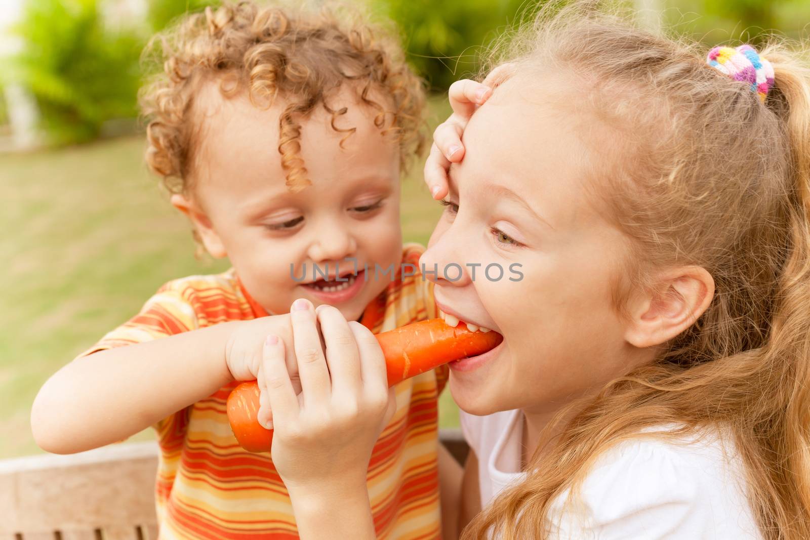 Happy little girl holding a carrots. Concept of healthy food. by altanaka