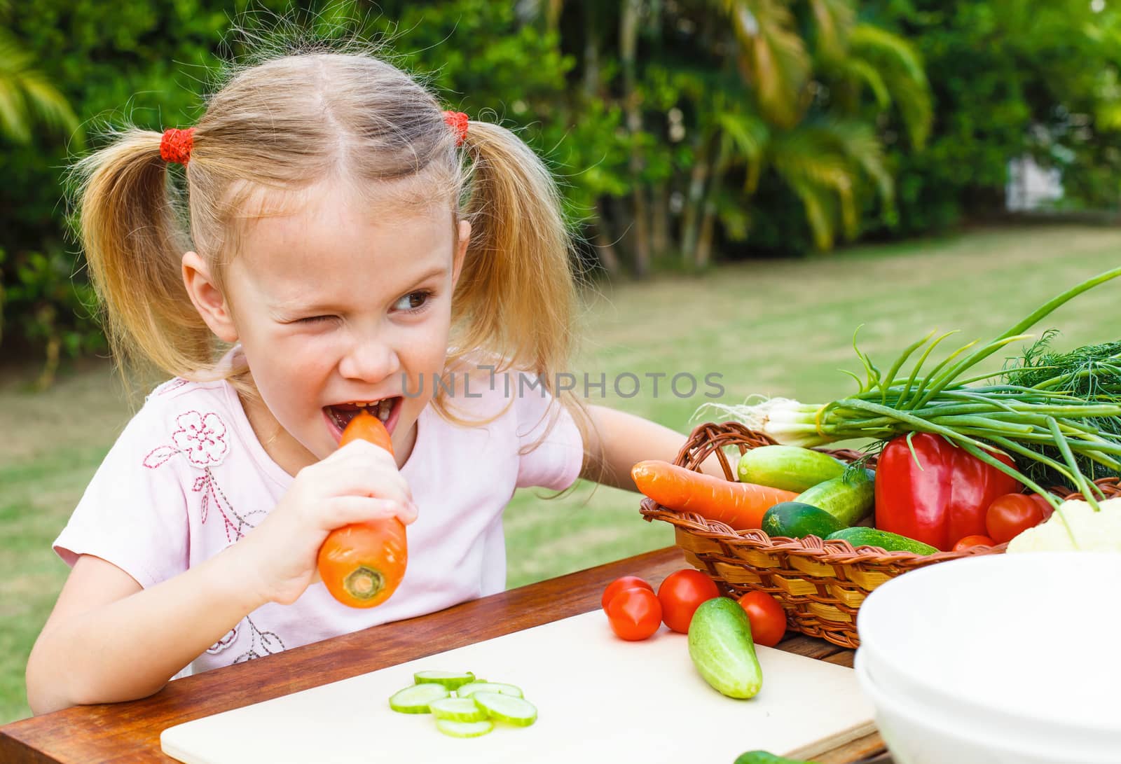 Happy little girl holding a carrots. Concept of healthy food.