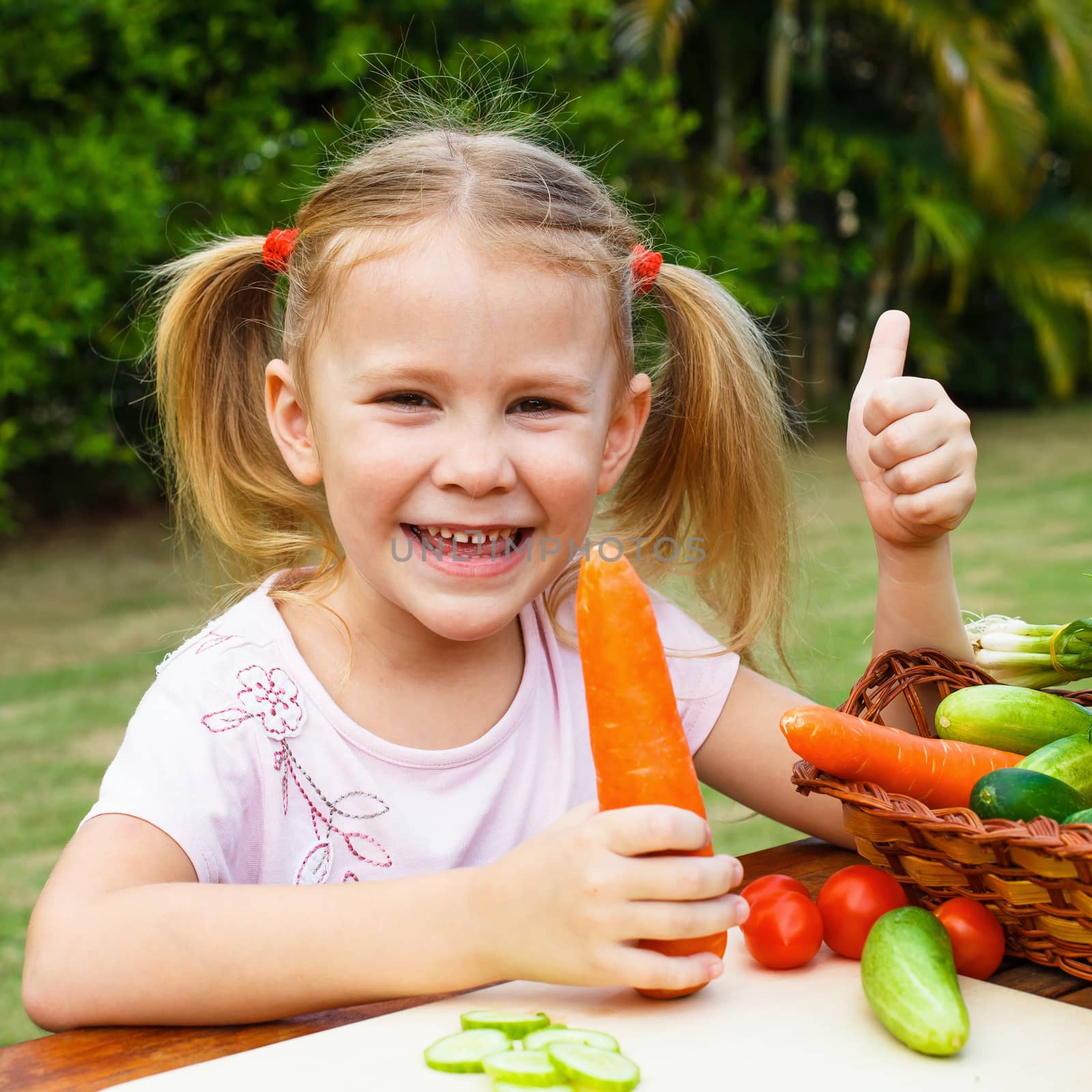 happy girl shows gesture cool and  holding a carrots. Concept of healthy food.