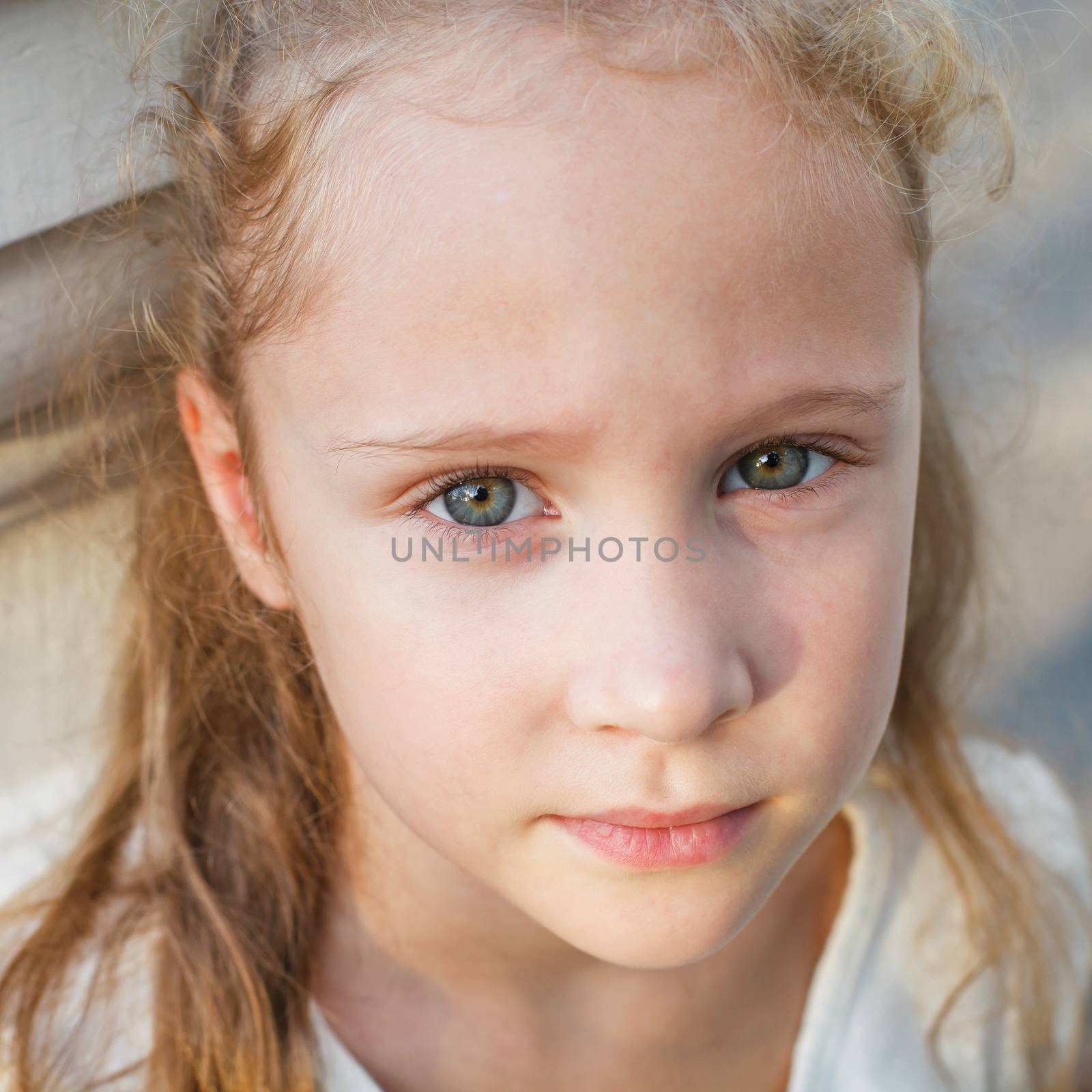 sad little girl on the background of an white wall