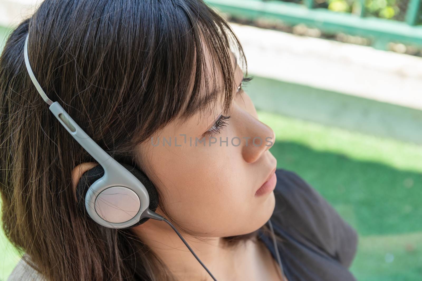 Teenage female with headphones and listening to music from mobile phone  at home