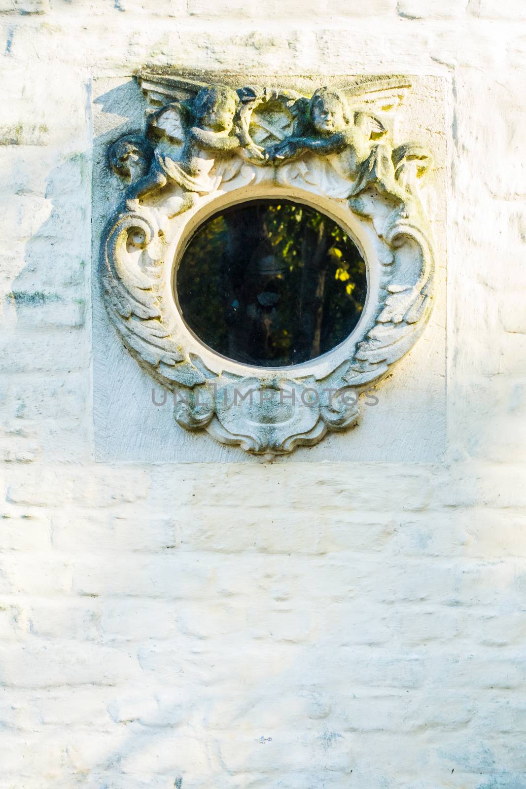 round window or porthole in white brick wall Bruges by paddythegolfer