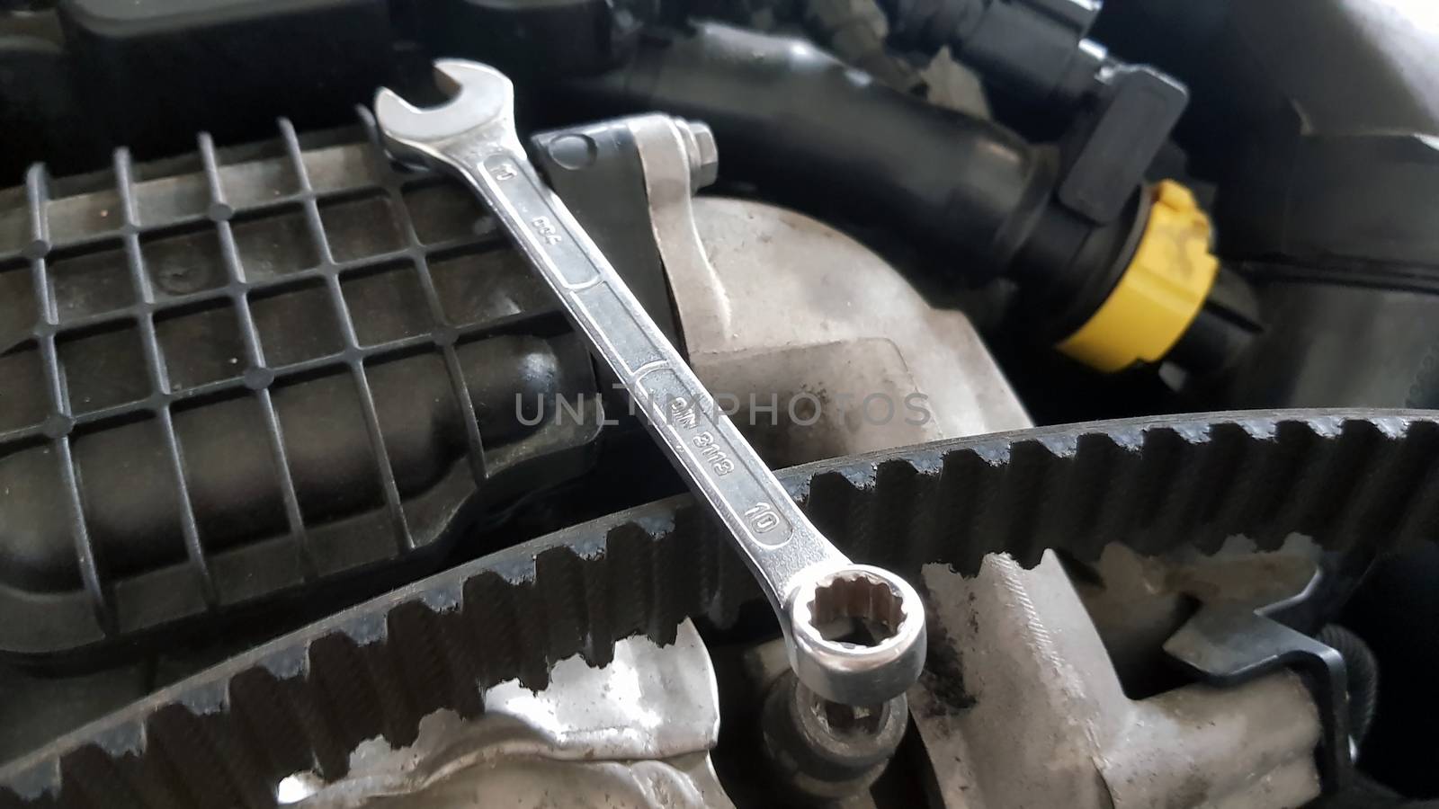 Spanner and timing belt on car engine by savcoco