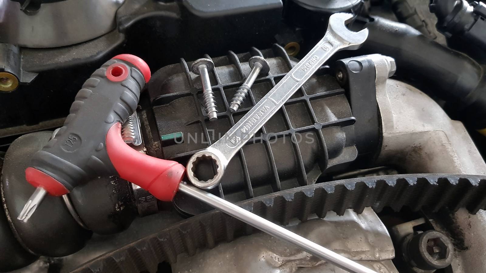 Service tools on car engine: spanner, screw, timing belt replace