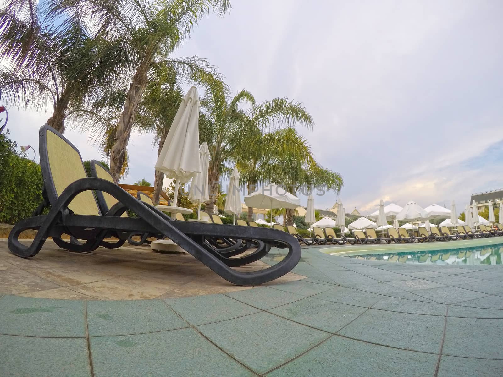 Summer resort: chaise longue near swimming pool in a mediterranean resort.