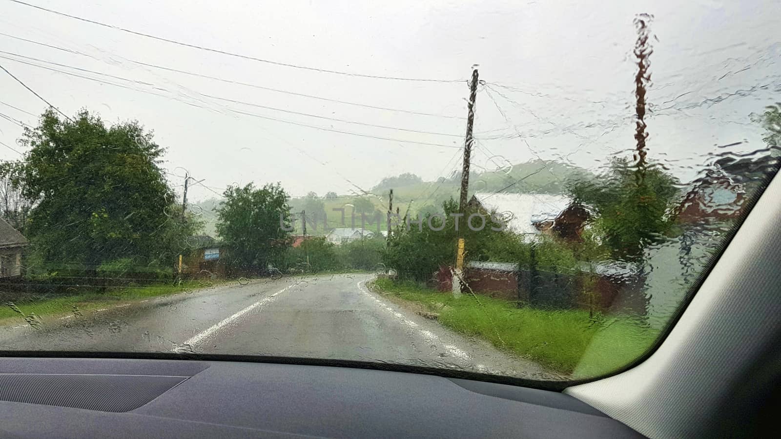 Road view through car windshield on heavy rain.