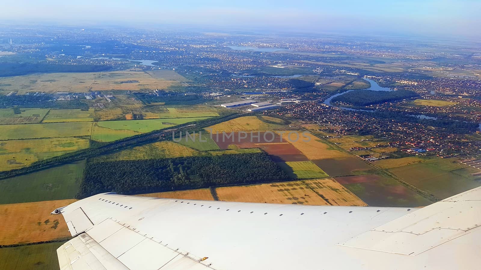 The wing of the plane taking off from Bucharest, aerial view of north of Bucharest