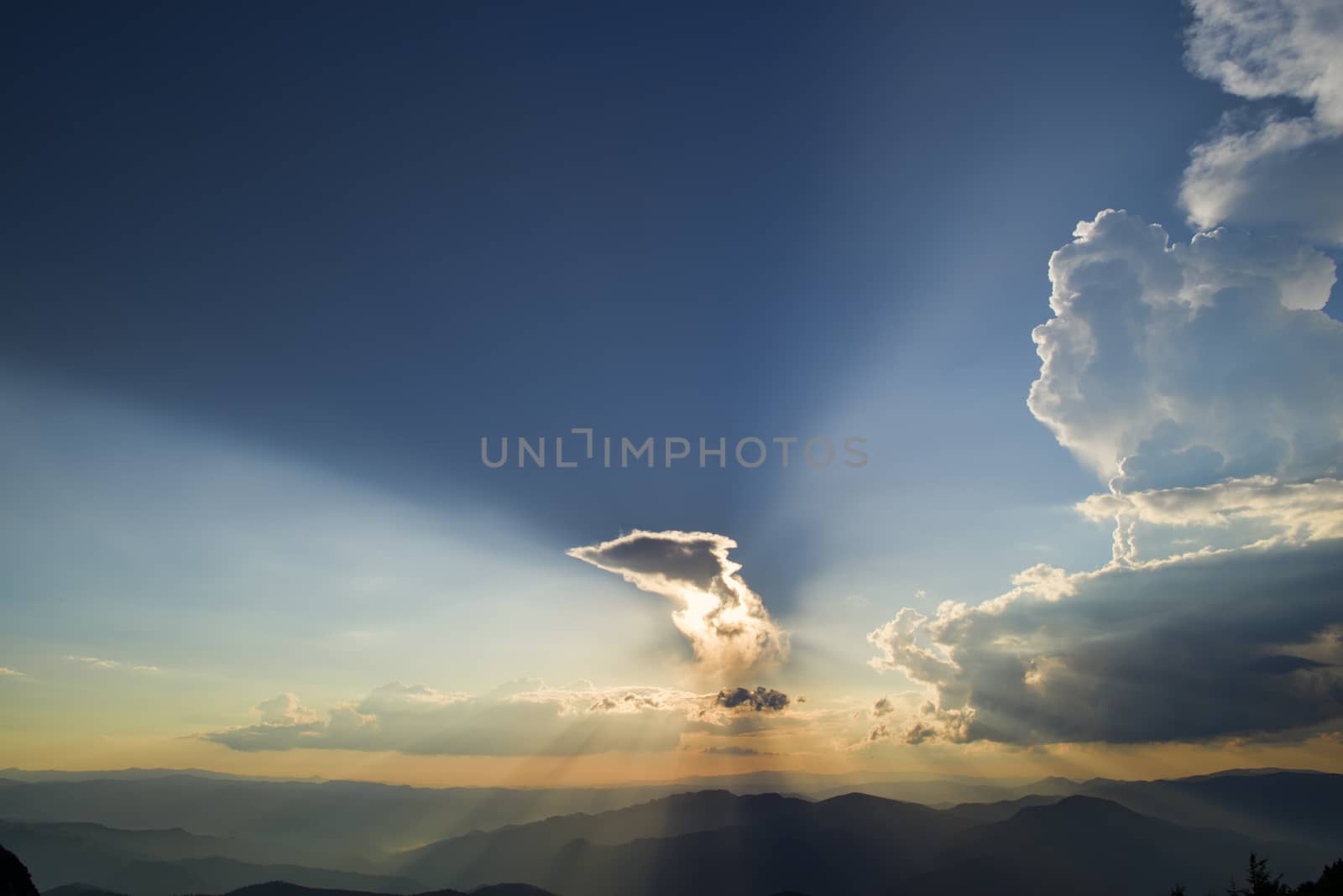 Sunset over clouds from the top, Sun rays over the mountains