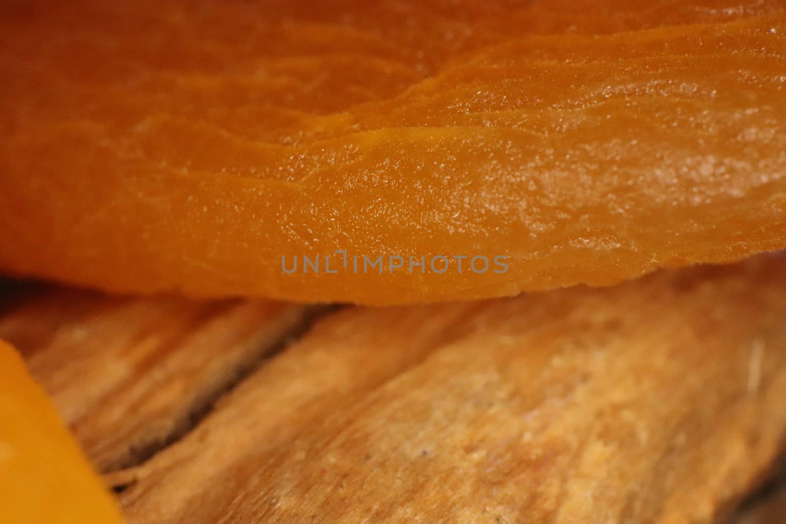 Dried Apricot on Wood Texture. Warm Nature Organic Background. Macro Closeup.