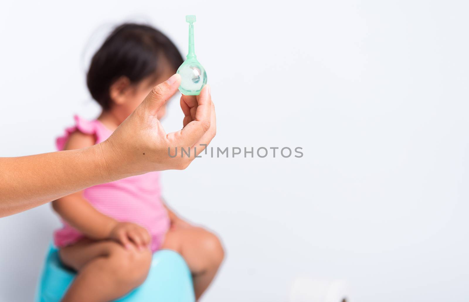 Asian little cute baby child girl training to sitting on blue chamber pot or potty her problem cannot shit and mother use Enema for help, studio shot isolated on white background, wc toilet concept