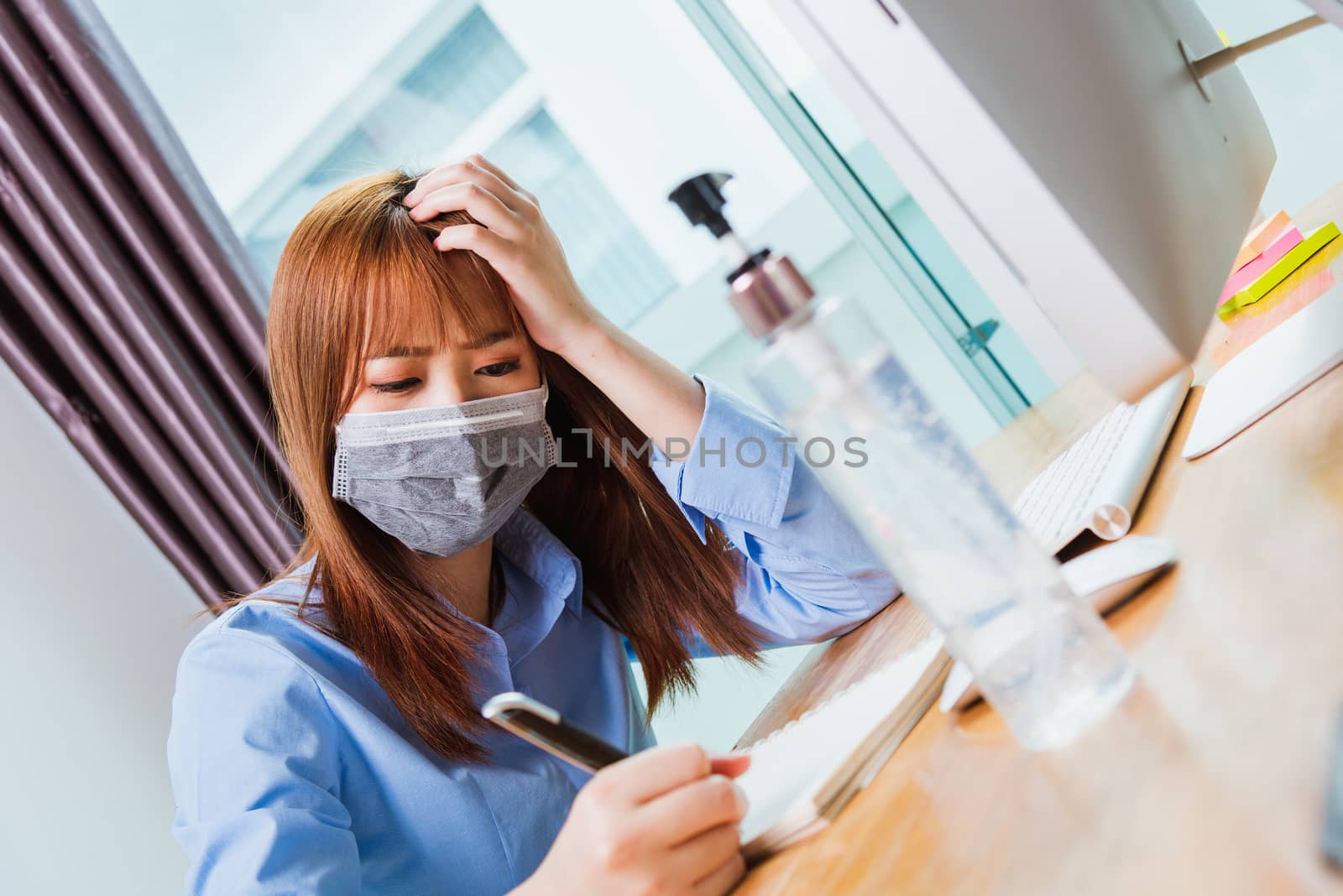 Asian young business woman wearing face mask protective working from home office with laptop computer he quarantines disease coronavirus or COVID-19 and write note booklist work today