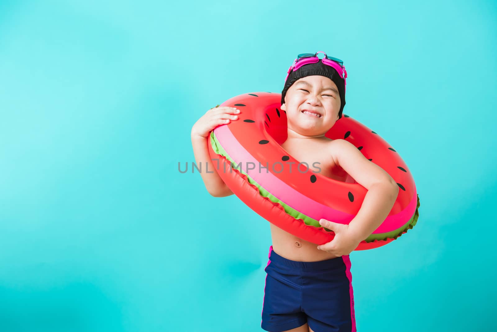 Child boy wearing goggles and swimsuit holding beach watermelon  by Sorapop