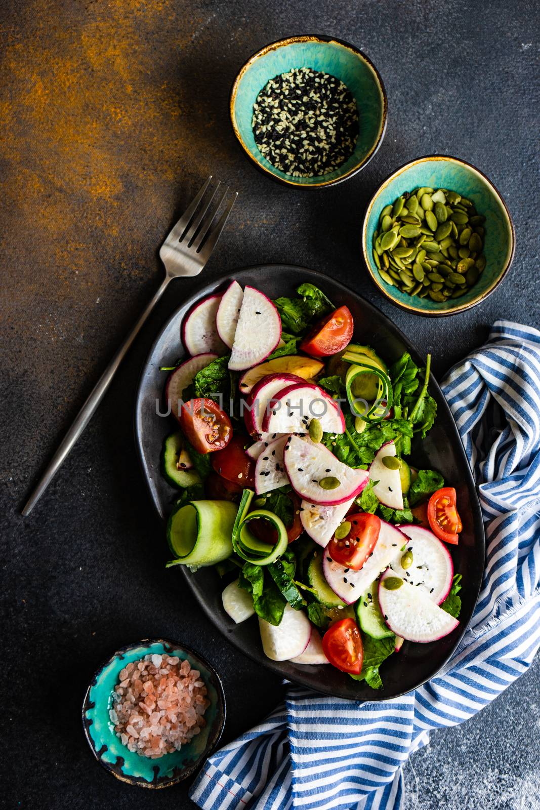 Healthy lifestyle food concept with mixed vegetable salad and seeds on rustic stone background with copy space